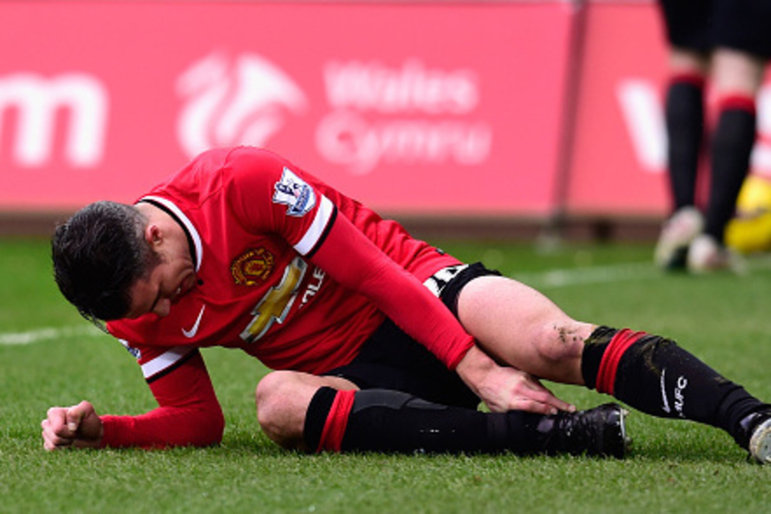 SWANSEA, WALES - FEBRUARY 21:  Robin Van Persie  of Manchester United lies injured during the Barclays Premier League match between Swansea City and Manchester United at Liberty Stadium on February 21, 2015 in Swansea, Wales.  (Photo by Stu Forster/Getty 