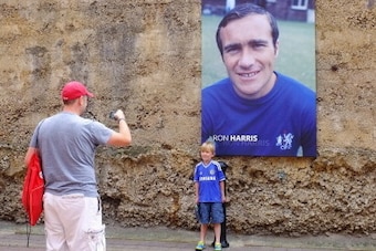 LONDON, ENGLAND - AUGUST 18: A young Chelsea fan has his photo taken in front of a picture of Ron Harris prior to the Barclays Premier League match between Chelsea and Hull City at Stamford Bridge on August 18, 2013 in London, England.  (Photo by Richard 