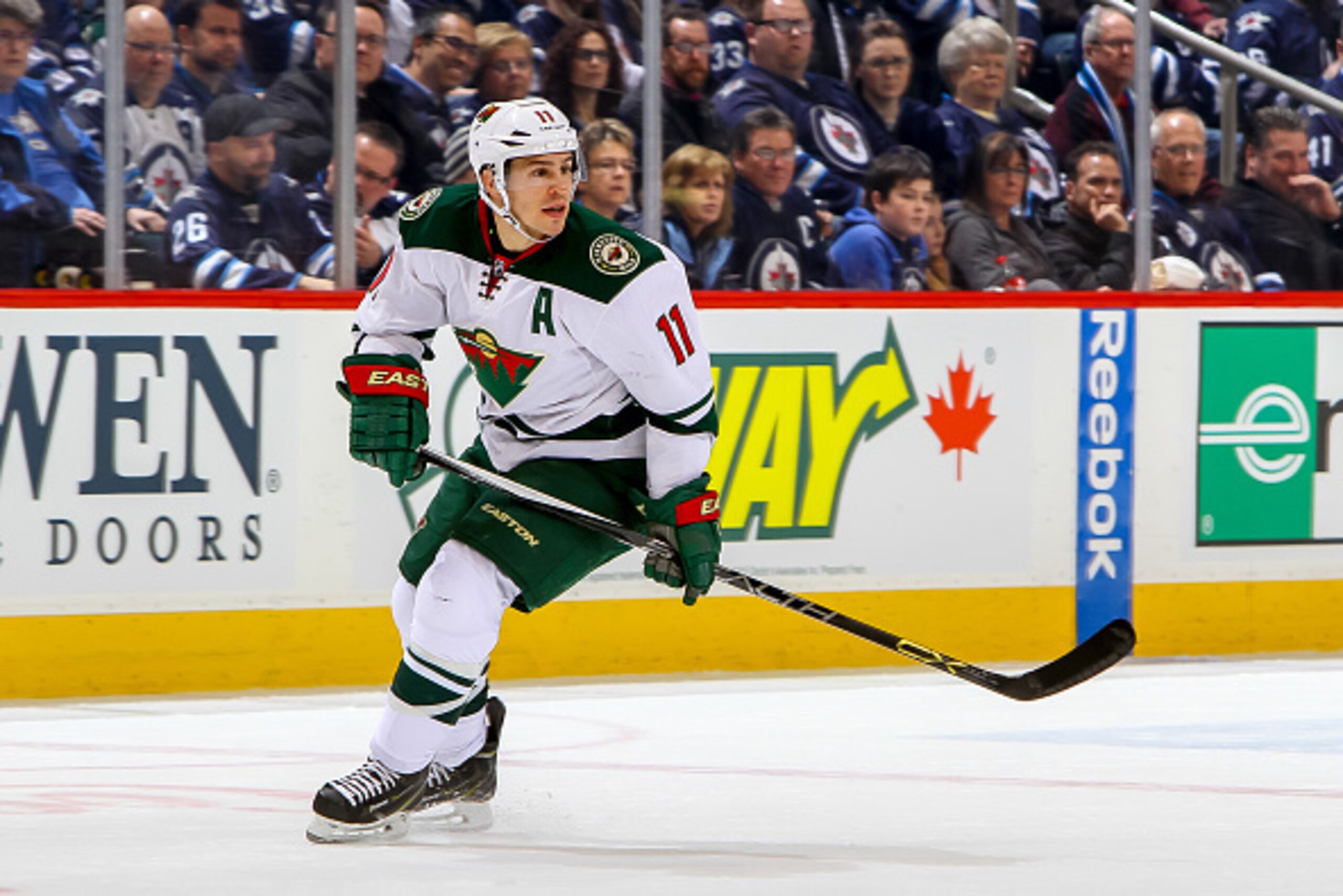 WINNIPEG, CANADA - FEBRUARY 10: Zach Parise #11 of the Minnesota Wild keeps an eye on the play during first period action against the Winnipeg Jets on February 10, 2015 at the MTS Centre in Winnipeg, Manitoba, Canada. The Jets defeated the Wild 2-1 in ove