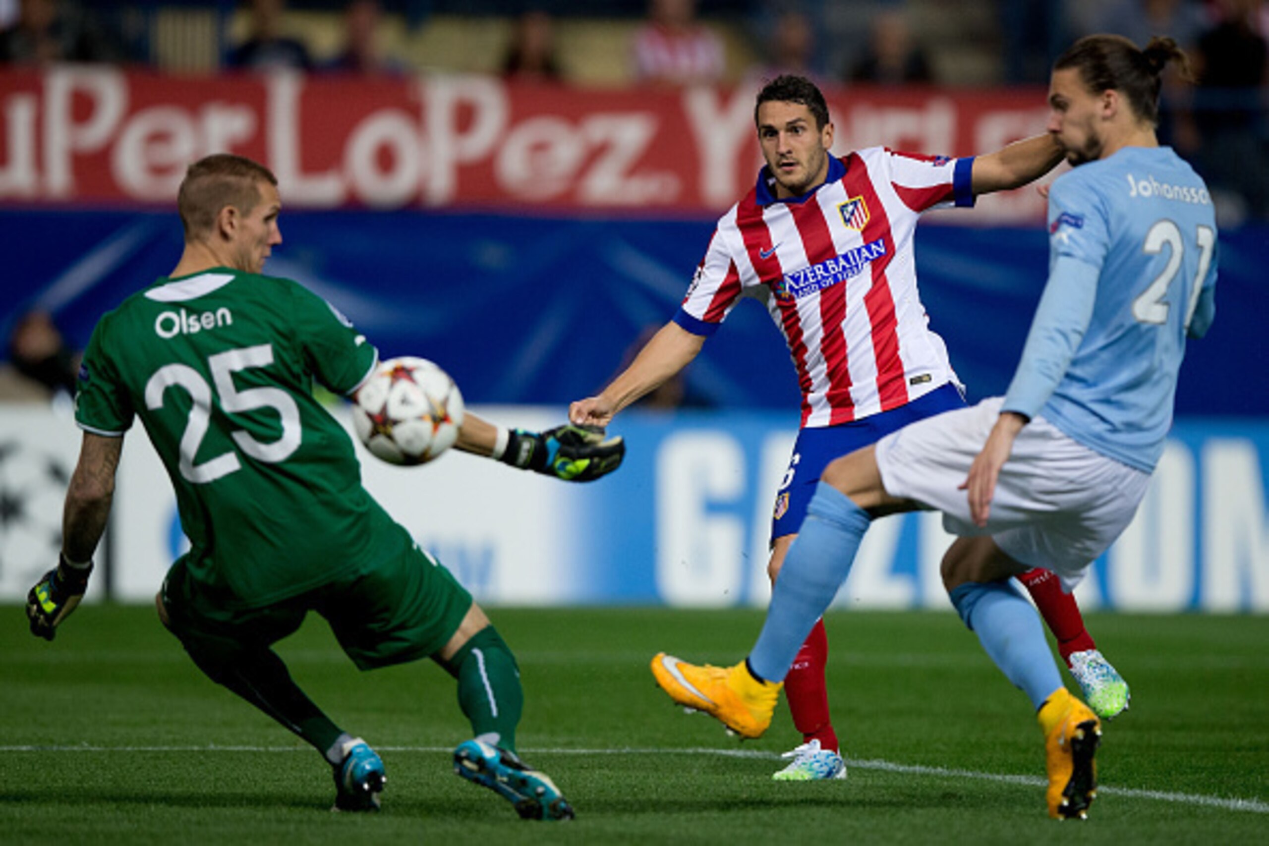 MADRID, SPAIN - OCTOBER 22: Koke (2ndR) of Atletico de Madrid scores their opening goal across goalkeeper Robin Olsen (L) of Malmo FF and his teammate Erik Johansson during the UEFA Champions League group A match between Club Atletico de Madrid and Malmo 
