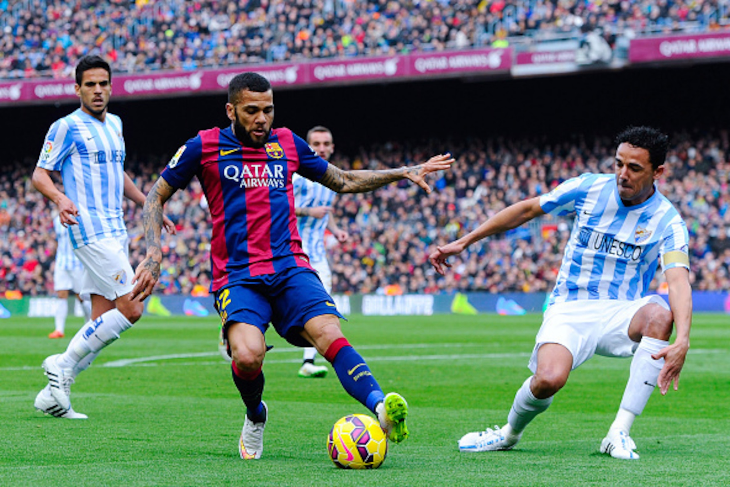BARCELONA, SPAIN - FEBRUARY 21: Dani Alves of FC Barcelona competes for the ball with Welligton Robson (R) and Miguel Torres of Malaga CF during the La Liga match between FC Barcelona and Malaga CF at Camp Nou on February 21, 2015 in Barcelona, Spain. ( BARCELONA, SPAIN - FEBRUARY 21: Dani Alves of FC Barcelona competes for the ball with Welligton Robson (R) and Miguel Torres of Malaga CF during the La Liga match between FC Barcelona and Malaga CF at Camp Nou on February 21, 2015 in Barcelona, Spain. (