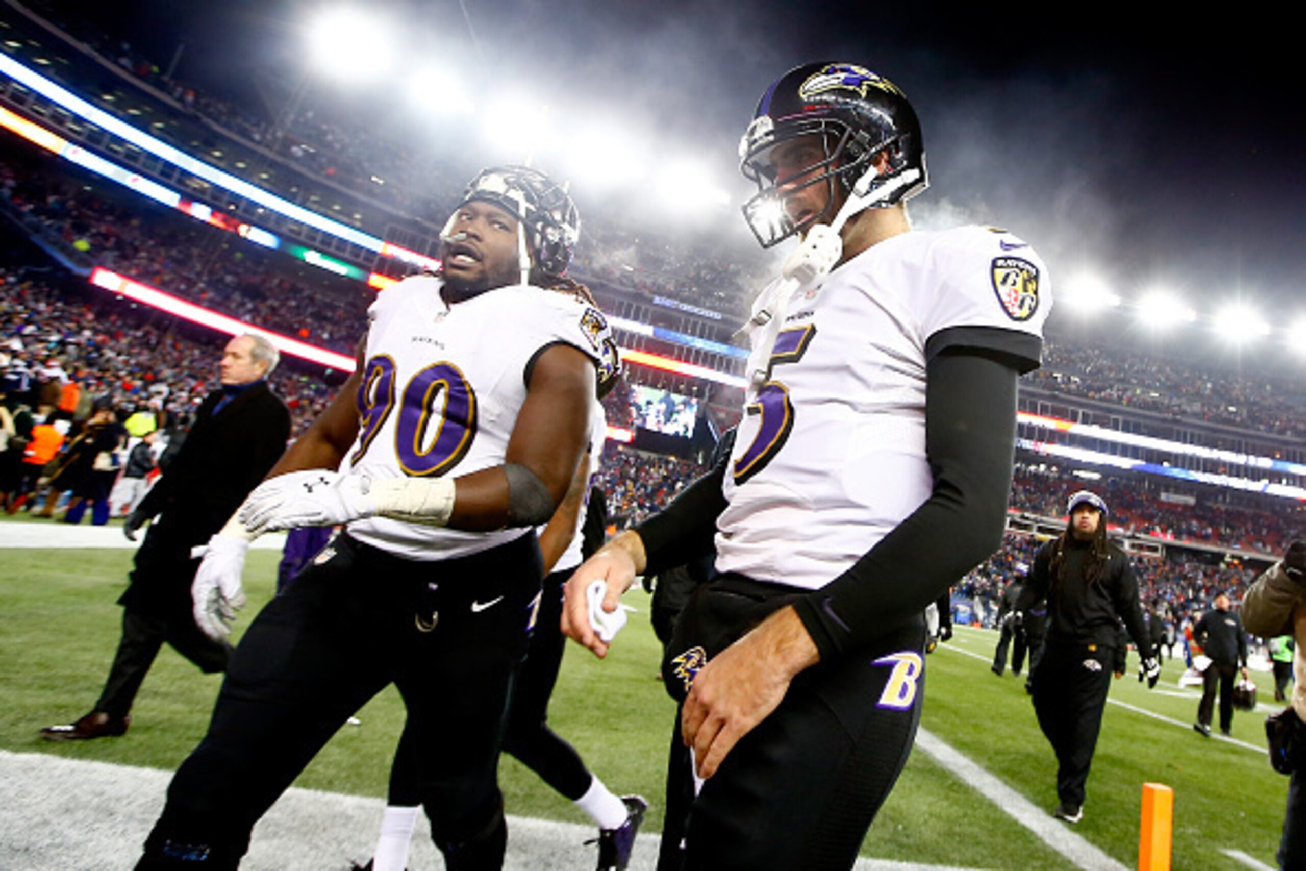 FOXBORO, MA - JANUARY 10:   Pernell McPhee #90 and Joe Flacco #5 of the Baltimore Ravens walk off the field following the 2015 AFC Divisional Playoffs game against the New England Patriots at Gillette Stadium on January 10, 2015 in Foxboro, Massachusetts.