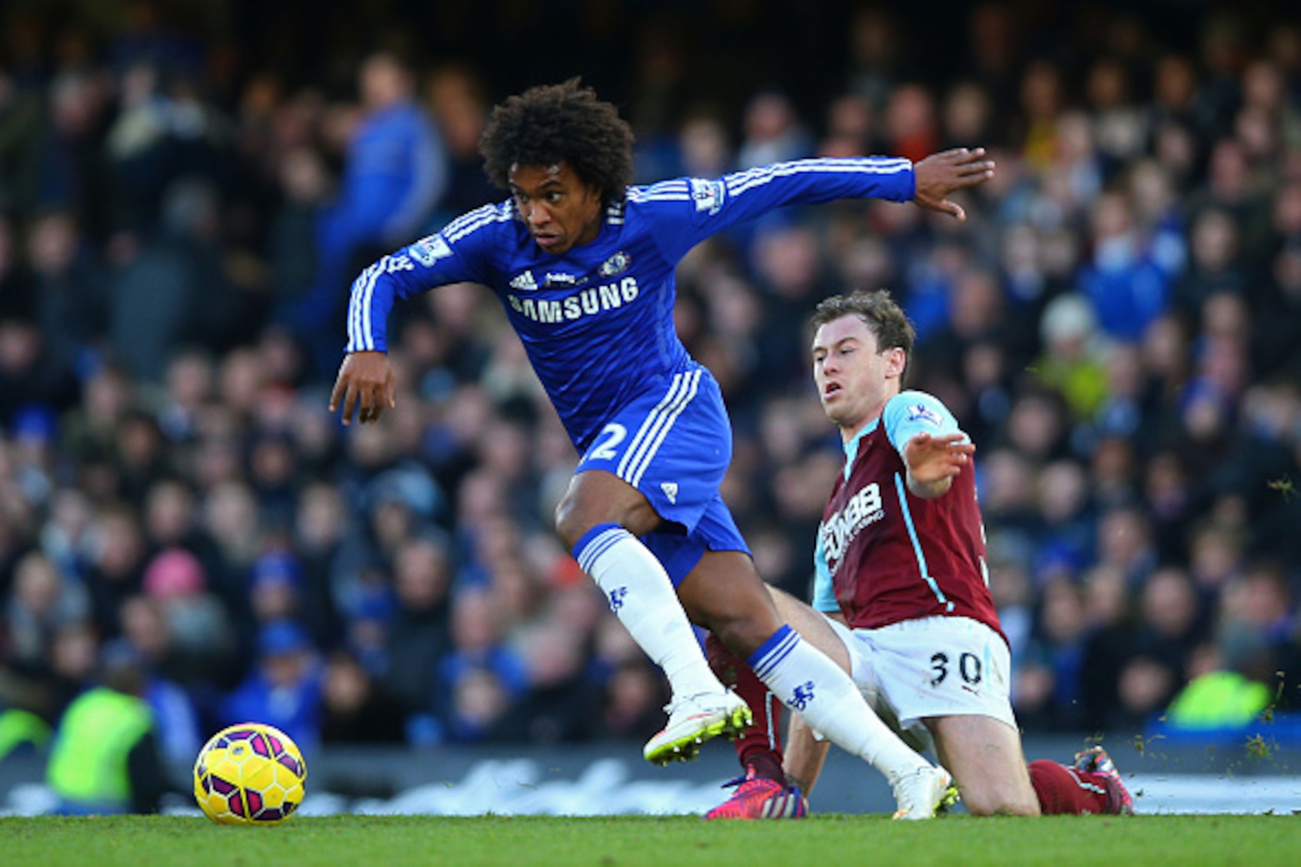 LONDON, ENGLAND - FEBRUARY 21:  Willian of Chelsea is tackled by Ashley Barnes of Burnley during the Barclays Premier League match between Chelsea and Burnley at Stamford Bridge on February 21, 2015 in London, England.  (Photo by Paul Gilham/Getty Images)