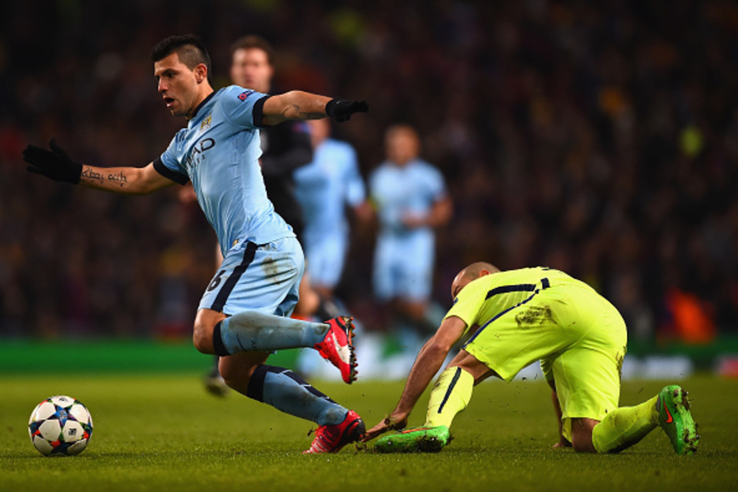MANCHESTER, ENGLAND - FEBRUARY 24: Sergio Aguero of Manchester City evades a challenge from Javier Mascherano of Barcelona  during the UEFA Champions League Round of 16 match between Manchester City and Barcelona at Etihad Stadium on February 24, 2015 in 