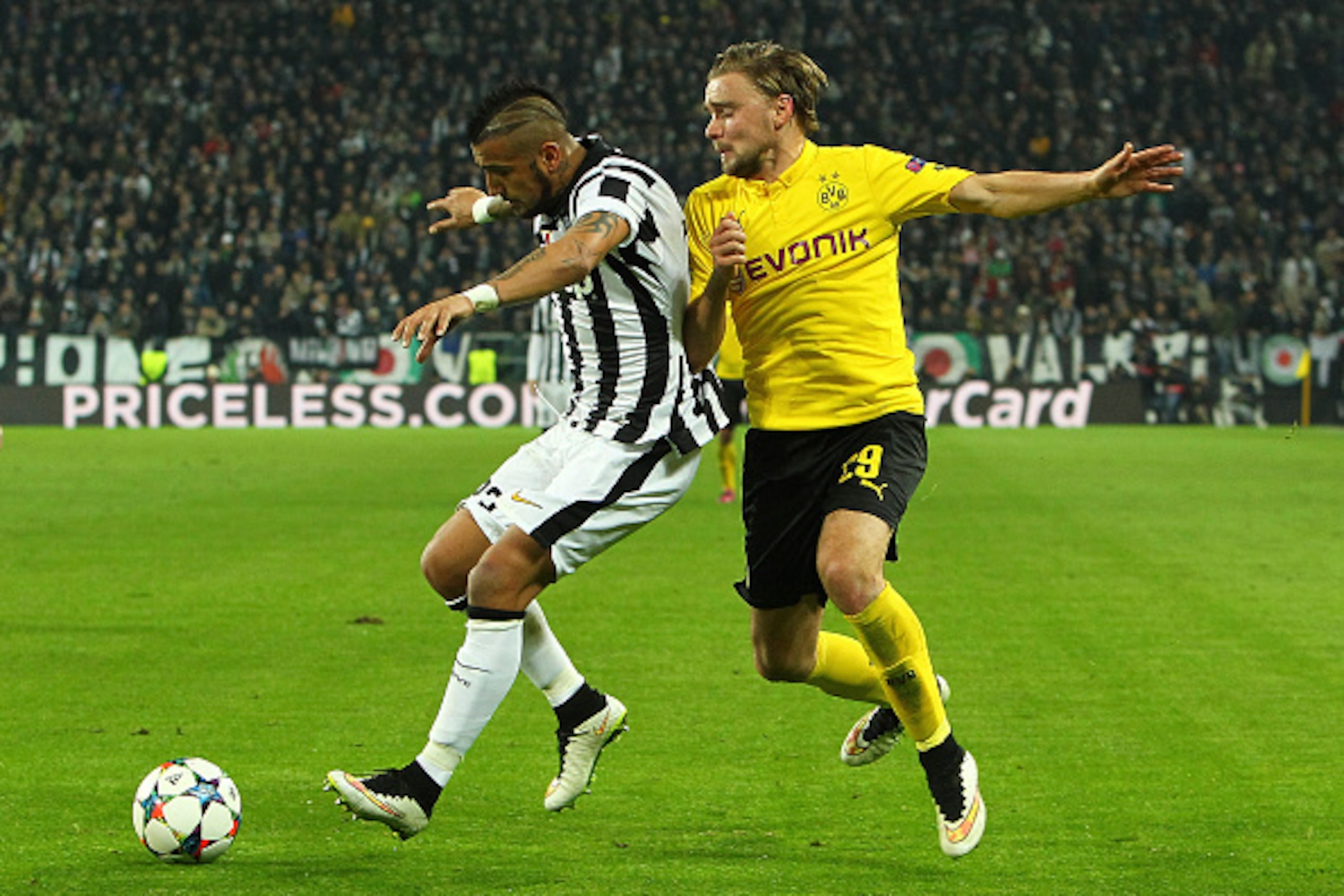 TURIN, ITALY - FEBRUARY 24:  Arturo Vidal of Borussia Dortmund competes for the ball with Marcel Schmelzer of Juventus FC during the UEFA Champions League Round of 16 match between Juventus and Borussia Dortmund at Juventus Arena on February 24, 2015 in T