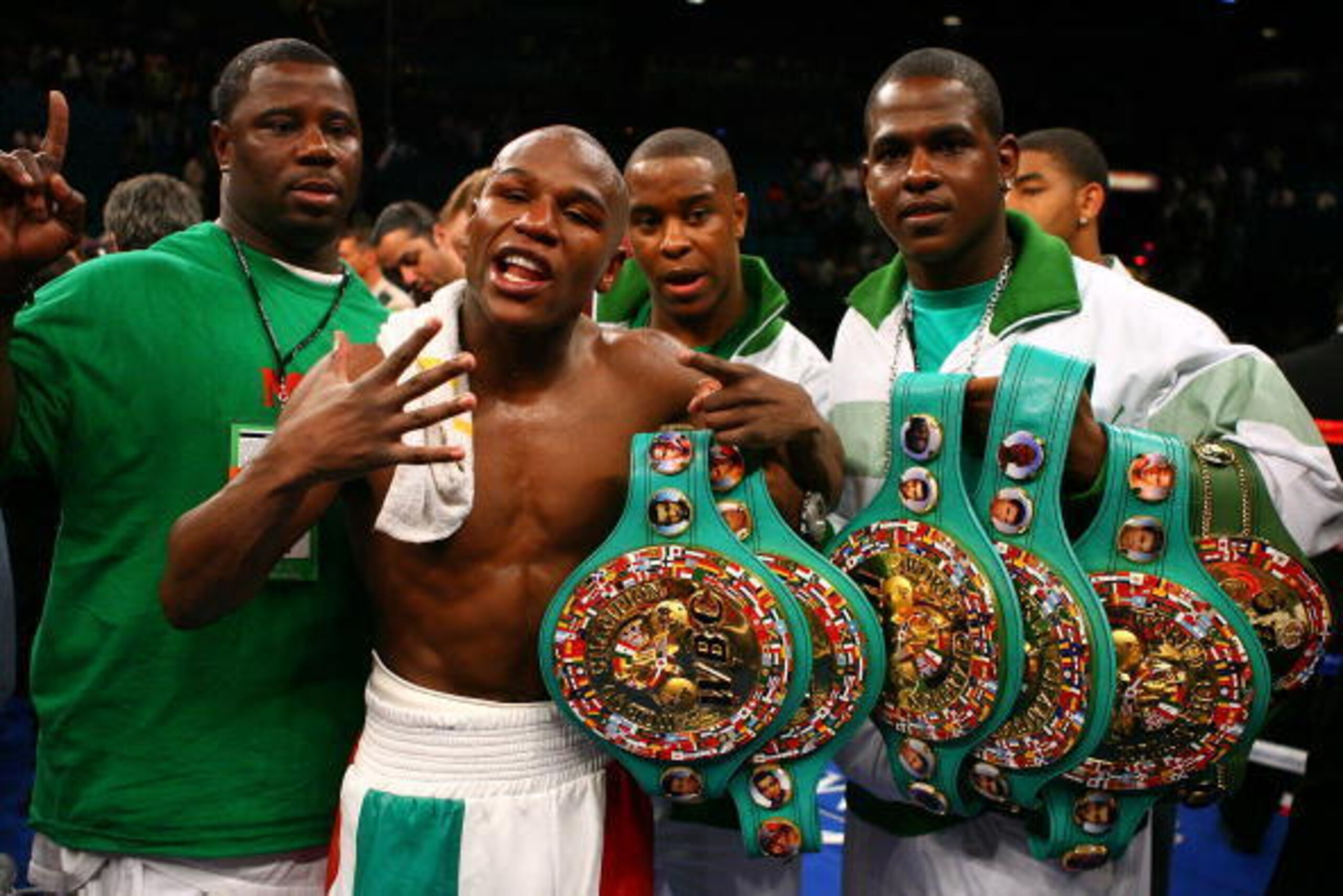 LAS VEGAS - MAY 05:  Floyd Mayweather Jr. (M)  celebrates his split decision victory against Oscar De La Hoya with two members of his camp after their WBC super welterweight championship fight at the MGM Grand Garden Arena May 5, 2007 in Las Vegas, Nevada