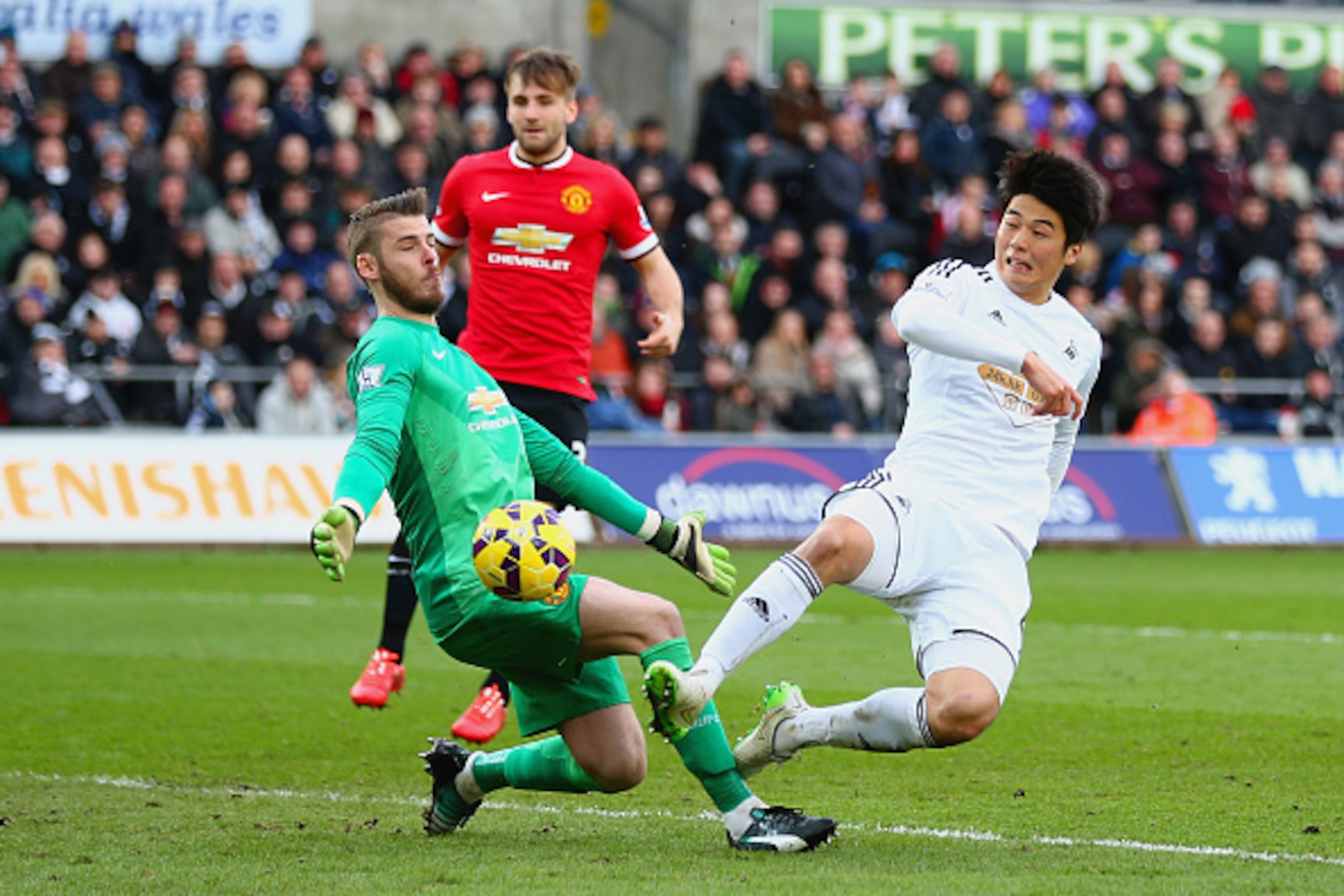 SWANSEA, WALES - FEBRUARY 21:  David De Gea of Manchester United makes a save from Ki Sung-Yueng of Swansea City during the Barclays Premier League match between Swansea City and Manchester United at Liberty Stadium on February 21, 2015 in Swansea, Wales.