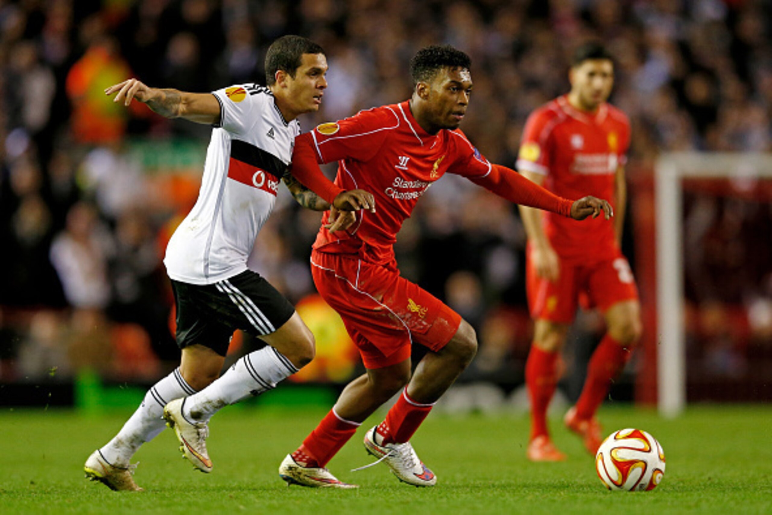 LIVERPOOL, ENGLAND - FEBRUARY 19: Daniel Sturridge of Liverpool holds off the challenge from Ramon de Moraes Motta of Besiktas during the UEFA Europa League Round of 32 match between Liverpool FC and Besiktas JK at Anfield on February 19, 2015 in Liverpo LIVERPOOL, ENGLAND - FEBRUARY 19: Daniel Sturridge of Liverpool holds off the challenge from Ramon de Moraes Motta of Besiktas during the UEFA Europa League Round of 32 match between Liverpool FC and Besiktas JK at Anfield on February 19, 2015 in Liverpo