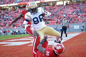 RALEIGH, NC - NOVEMBER 08:  Darren Waller #88 of the Georgia Tech Yellow Jackets beats defenders Mike Stevens #30 and Germaine Pratt #31 of the North Carolina State Wolfpack during their game at Carter-Finley Stadium on November 8, 2014 in Raleigh, North 
