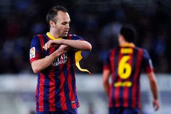 SAN SEBASTIAN, SPAIN - FEBRUARY 12:  Andres Iniesta of FC Barcelona adjusts the Captain armband as his teammate Xavi Hernandez of FC Barcelona leaves the pitch during the Copa del Rey Semi Final second leg match between Real Sociedad and FC Barcelona at A