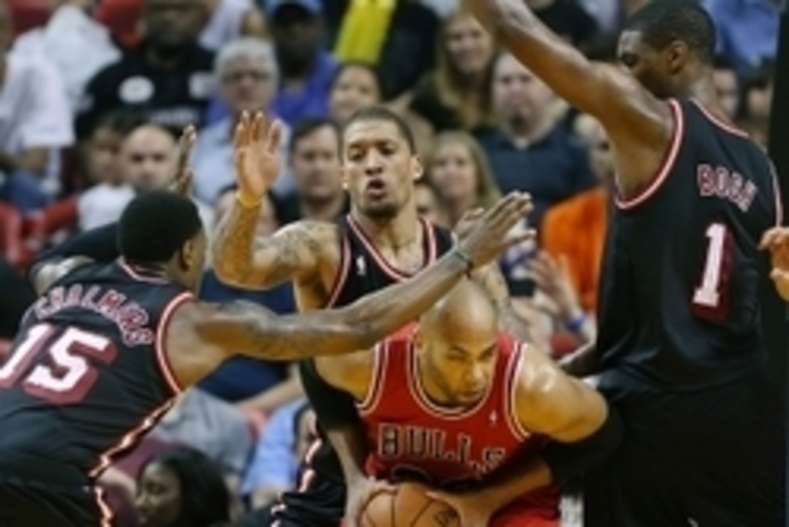 Feb 23, 2014; Miami, FL, USA; Chicago Bulls power forward Taj Gibson (22) is defended by Miami Heat center Chris Bosh (1) point guard Mario Chalmers (15) and small forward Michael Beasley (back) in the second half at American Airlines Arena.The Heat won 9
