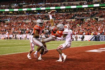 INDIANAPOLIS, IN - DECEMBER 06:  Devin Smith #9 of the Ohio State Buckeyes catches the ball over Sojourn Shelton #8 of the Wisconsin Badgers to score a touchdown in the first quarter of the Big Ten Championship game at Lucas Oil Stadium on December 6, 201