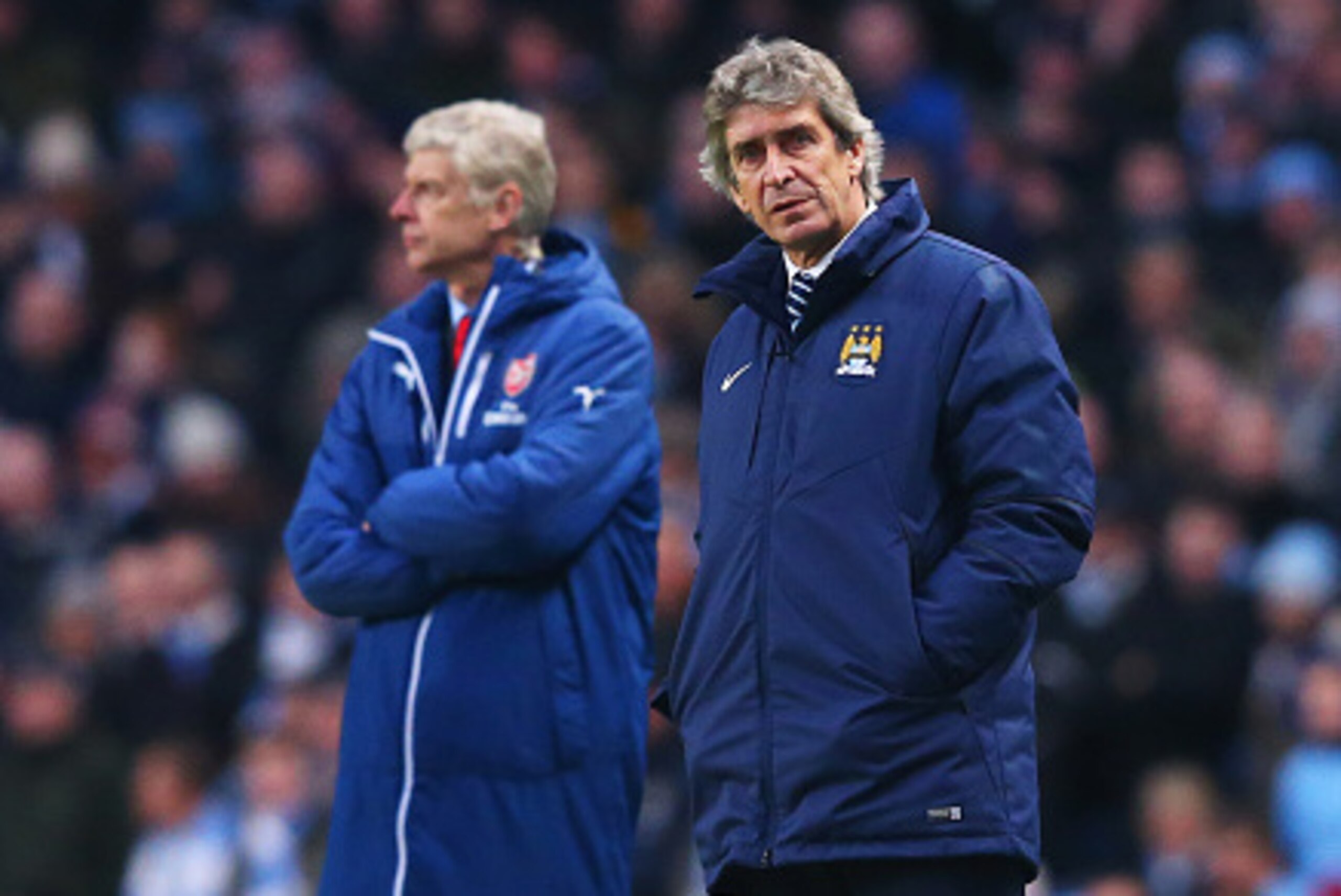 MANCHESTER, ENGLAND - JANUARY 18:  Arsene Wenger manager of Arsenal and Manuel Pellegrini manager of Manchester City look on from the touchline during the Barclays Premier League match between Manchester City and Arsenal at Etihad Stadium on January 18, 2