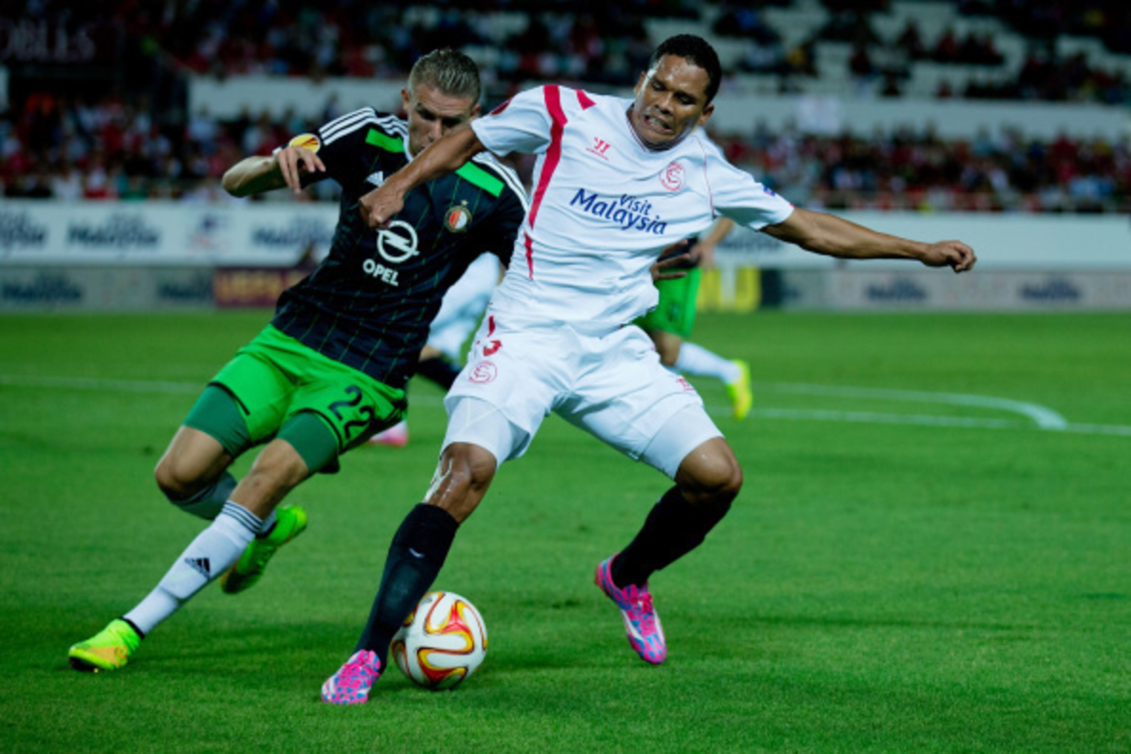 SEVILLE, SPAIN - SEPTEMBER 18: Carlos Bacca (L) of Sevilla FC competes for the ball with Sven van Beek (L) of Feyenoord during the UEFA Europa League group G match between Sevilla FC and Feyenoord at Ramon Sanchez Pizjuan stadium on September 18, 2014 in 