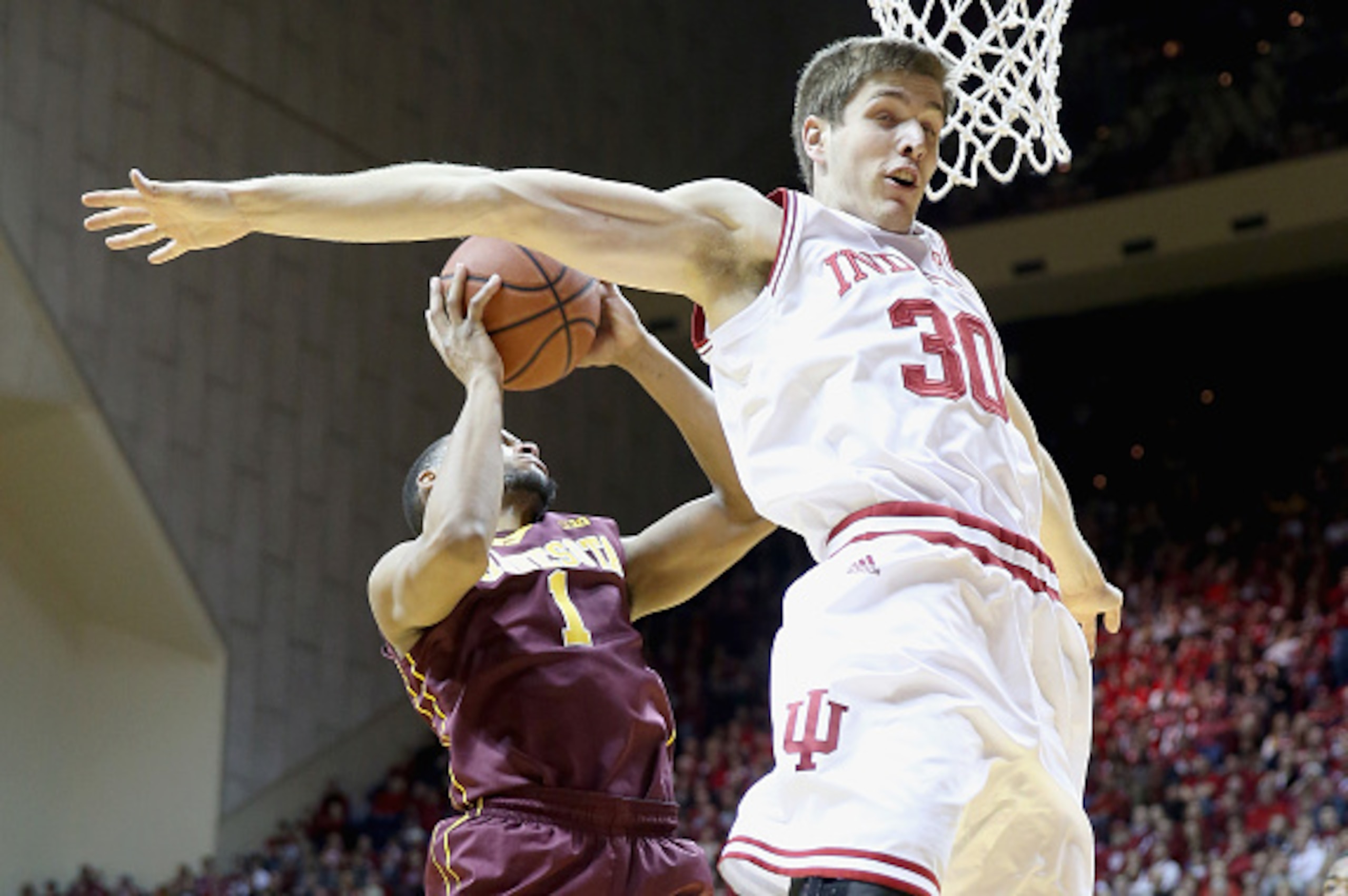 BLOOMINGTON, IN - FEBRUARY 15:  Colin Hartman #30 of the Indiana Hoosiers defends the shot of Andre Hollins #1 of the Minnesota Golden Golphers at Assembly Hall on February 15, 2015 in Bloomington, Indiana.  (Photo by Andy Lyons/Getty Images)