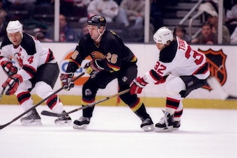 14 Nov 1996:  Center Mike Sillinger of the Vancouver Canucks is double-teamed by left wing Kevin Stevens and right wing Steve Thomas of the New Jersey Devils during a game at the Continental Airlines Arena in East Rutherford, New Jersey.  The Canucks won 
