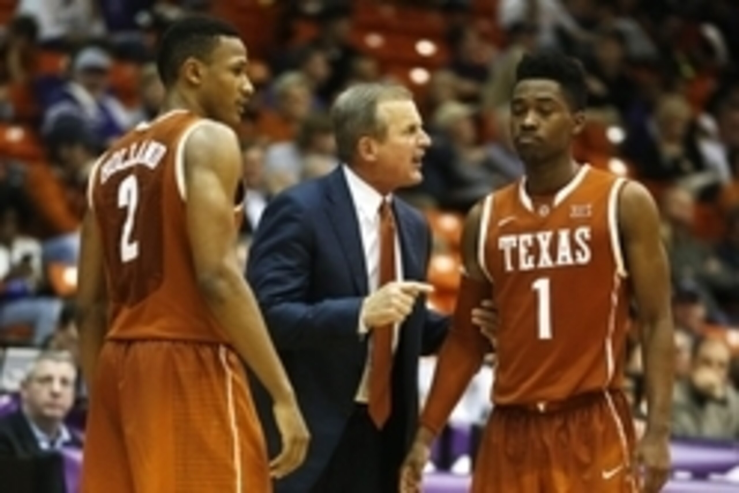 Jan 19, 2015; Fort Worth, TX, USA; Texas Longhorns head coach Rick Barnes talks with guard Isaiah Taylor (1) and guard Demarcus Holland (2) during a time out in the game against the TCU Horned Frogs at Wilkerson-Greines Athletic Center. Texas beat  TCU 66