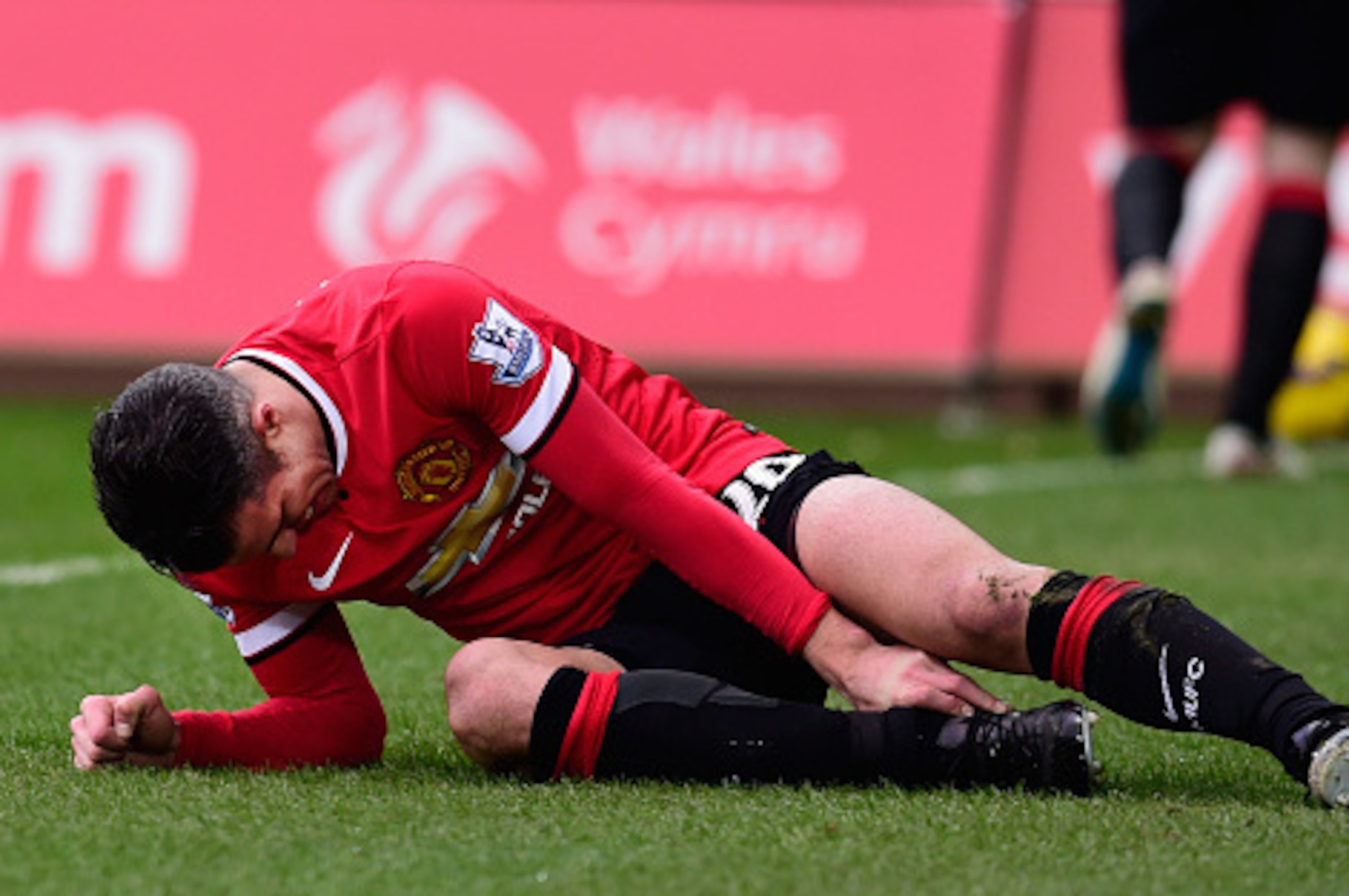 SWANSEA, WALES - FEBRUARY 21:  Robin Van Persie  of Manchester United lies injured during the Barclays Premier League match between Swansea City and Manchester United at Liberty Stadium on February 21, 2015 in Swansea, Wales.  (Photo by Stu Forster/Getty 