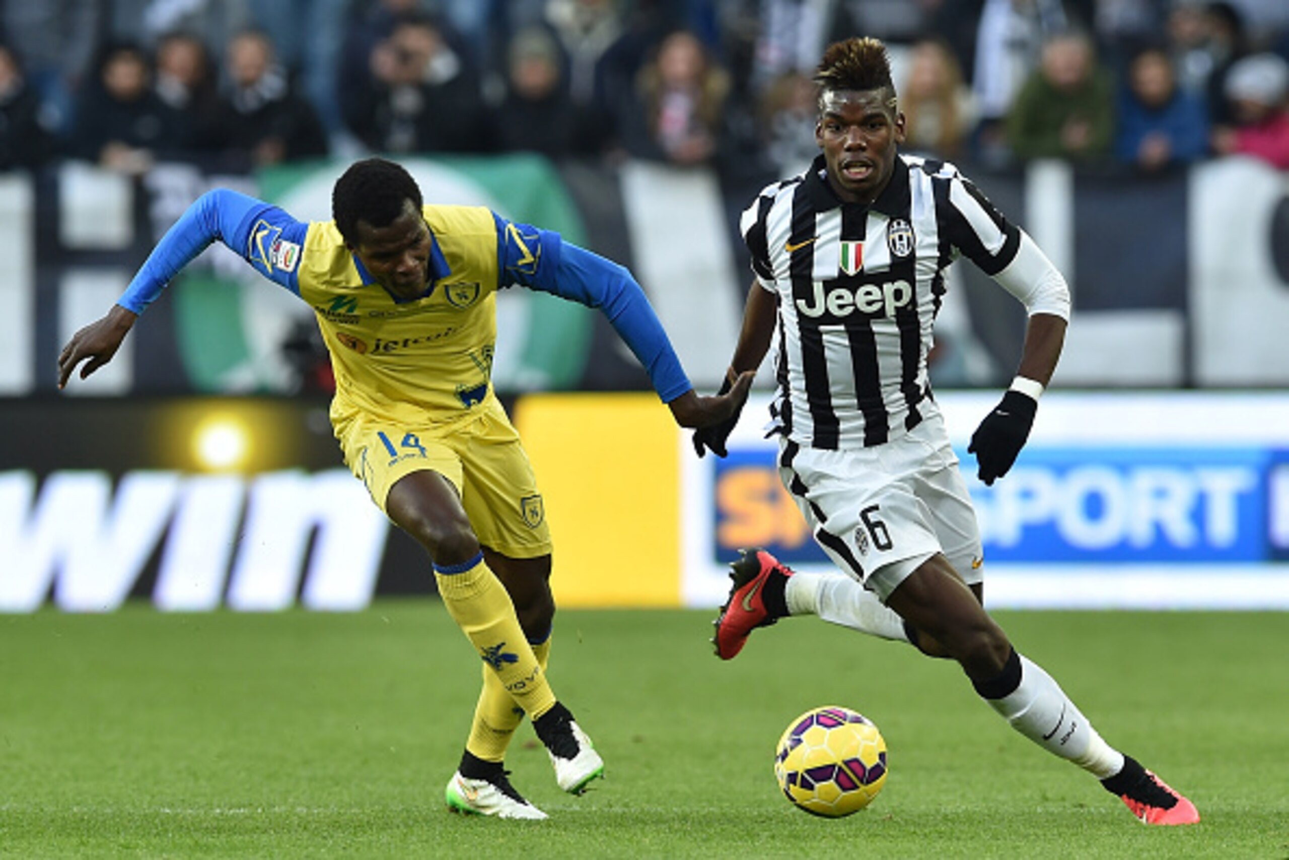 TURIN, ITALY - JANUARY 25:  Paul Pogba (R) of Juventus FC in action against Isaac Cofie of AC Chievo Verona during the Serie A match between Juventus FC and AC Chievo Verona at Juventus Arena on January 25, 2015 in Turin, Italy.  (Photo by Valerio Pennici