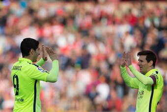 GRANADA, SPAIN - FEBRUARY 28:  Lionel Messi (R) of FC Barcelona celebrates scoring their third goal with teammate Luis Suarez (L) during the La Liga match between Granada CF and FC Barcelona at Nuevo Estadio de los Carmenes on February 28, 2015 in Granada