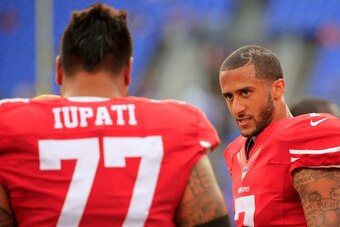 BALTIMORE, MD - AUGUST 07: Quarterback quarterback Colin Kaepernick #7 of the San Francisco 49ers talks with teammate Mike Iupati #77 before the start of their NFL pre-season game against the Baltimore Ravens at M&T Bank Stadium on August 7, 2014 in Balti