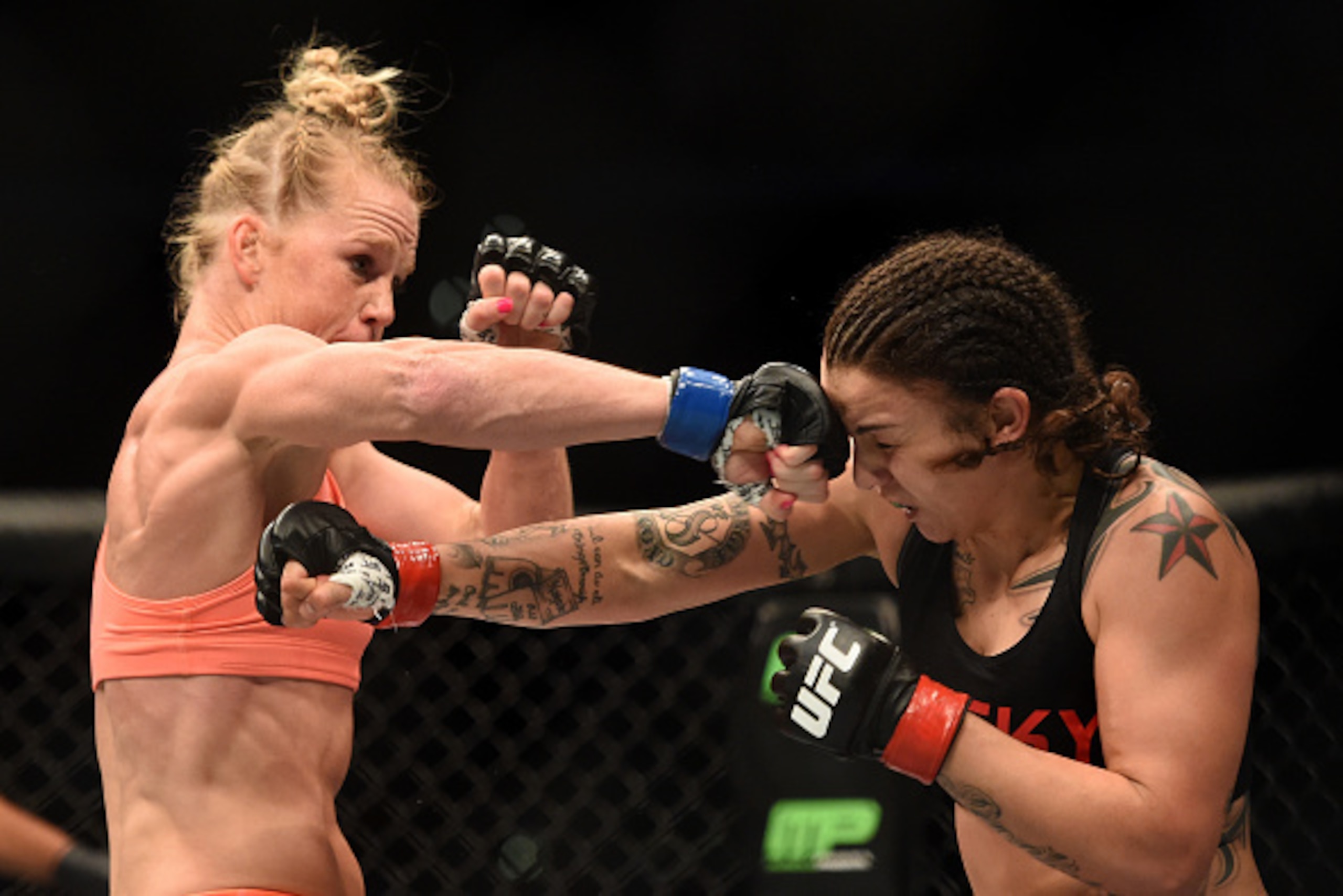 LOS ANGELES, CA - FEBRUARY 28:  (L-R) Holly Holms and Raquel Pennington exchange punches in their women's bantamweight bout during the UFC 184 event at Staples Center on February 28, 2015 in Los Angeles, California.  (Photo by Harry How/Getty Images)