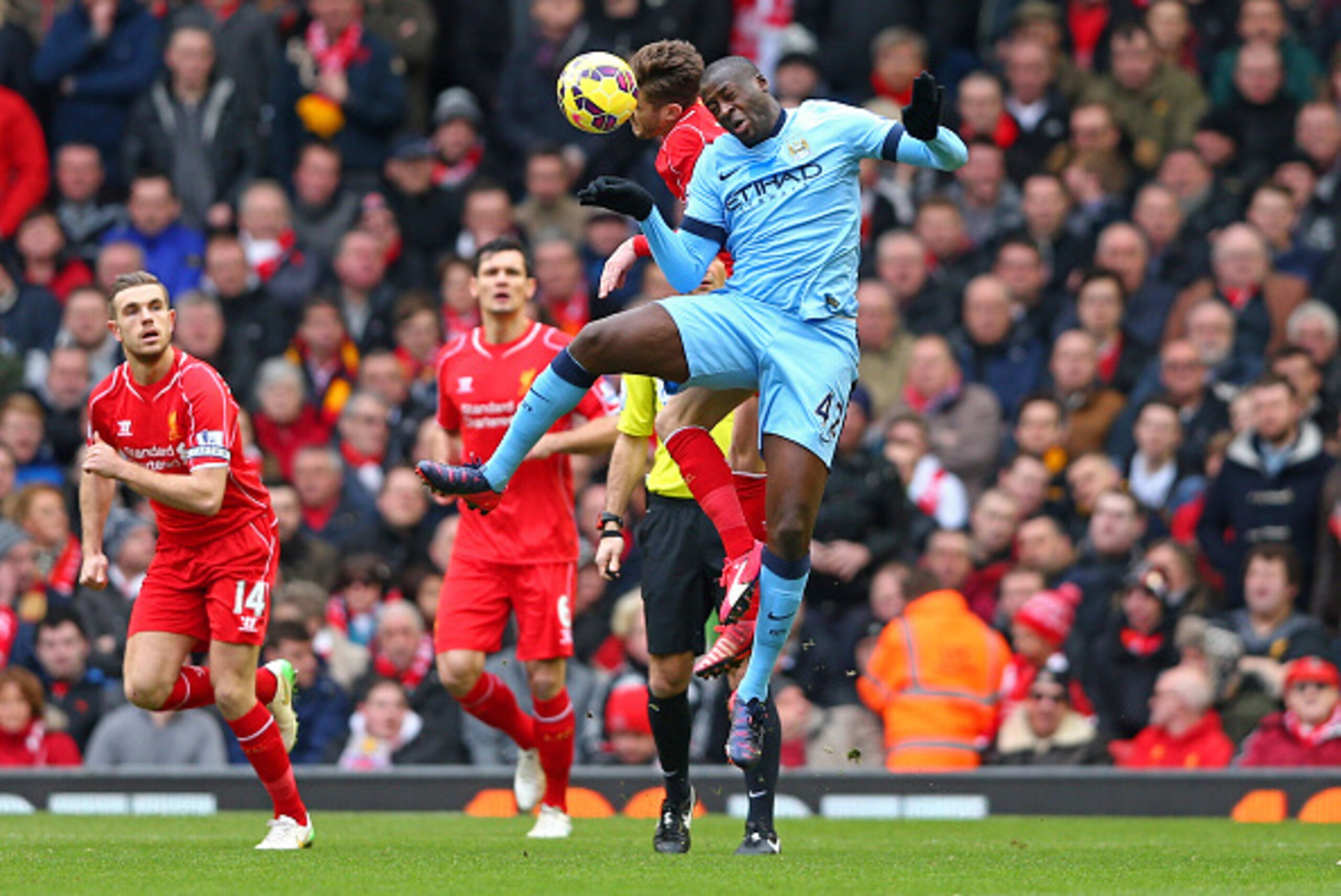 LIVERPOOL, ENGLAND - MARCH 01:  Yaya Toure of Manchester City and Adam Lallana of Liverpool compete for a header during the Barclays Premier League match between Liverpool and Manchester City at Anfield on March 1, 2015 in Liverpool, England.  (Photo by C