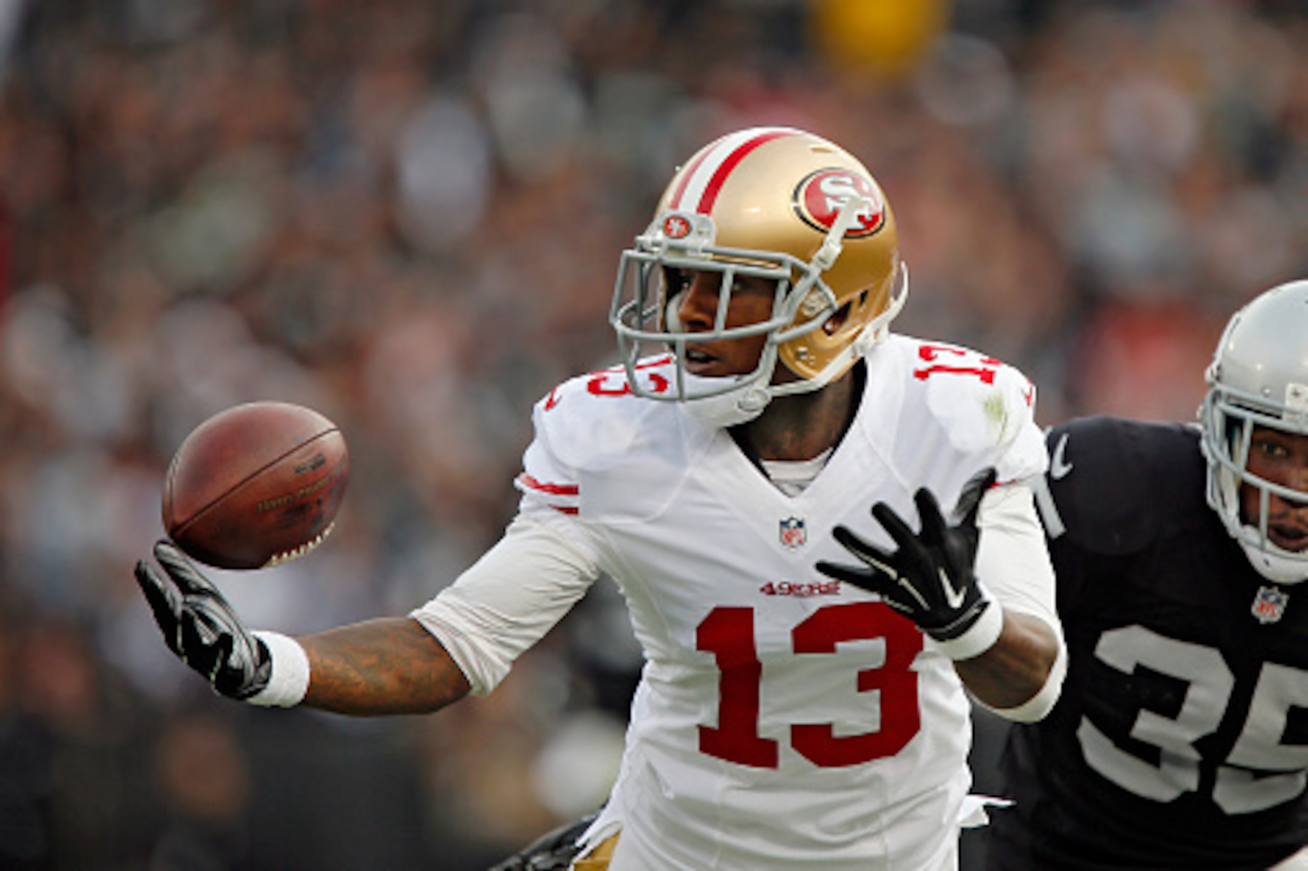 OAKLAND, CA - DECEMBER 7:  Wide receiver Stevie Johnson #13 of the San Francisco 49ers tries unsuccessfully to pull down a pass against cornerback Chimdi Chekwa #35 of the Oakland Raiders in the second quarter on December 7, 2014 at O.co Coliseum in Oakla