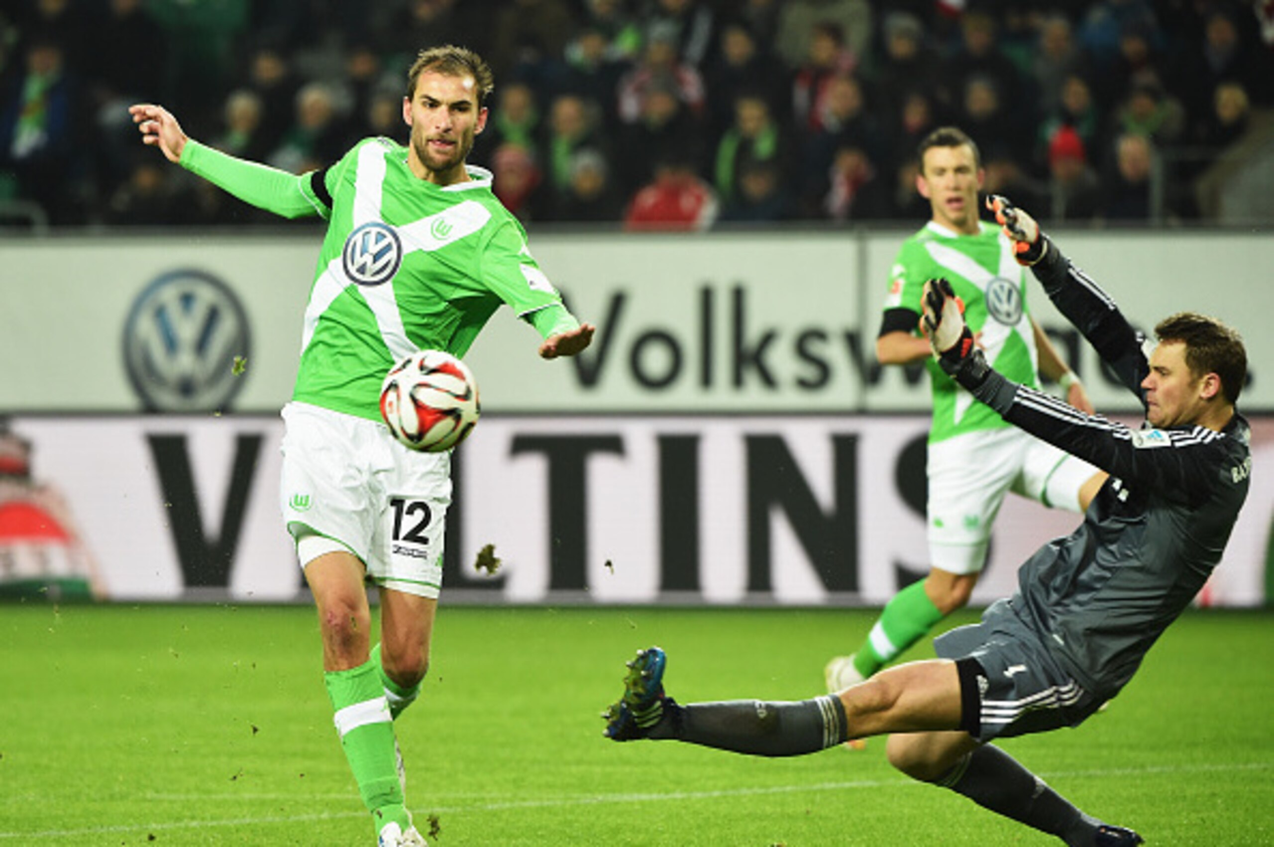 WOLFSBURG, GERMANY - JANUARY 30:  Bas Dost of Wolfsburg chips the ball past Manuel Neuer of Muenchen during the Bundesliga match between VfL Wolfsburg and FC Bayern Muenchen at Volkswagen Arena on January 30, 2015 in Wolfsburg, Germany.  (Photo by Stuart 