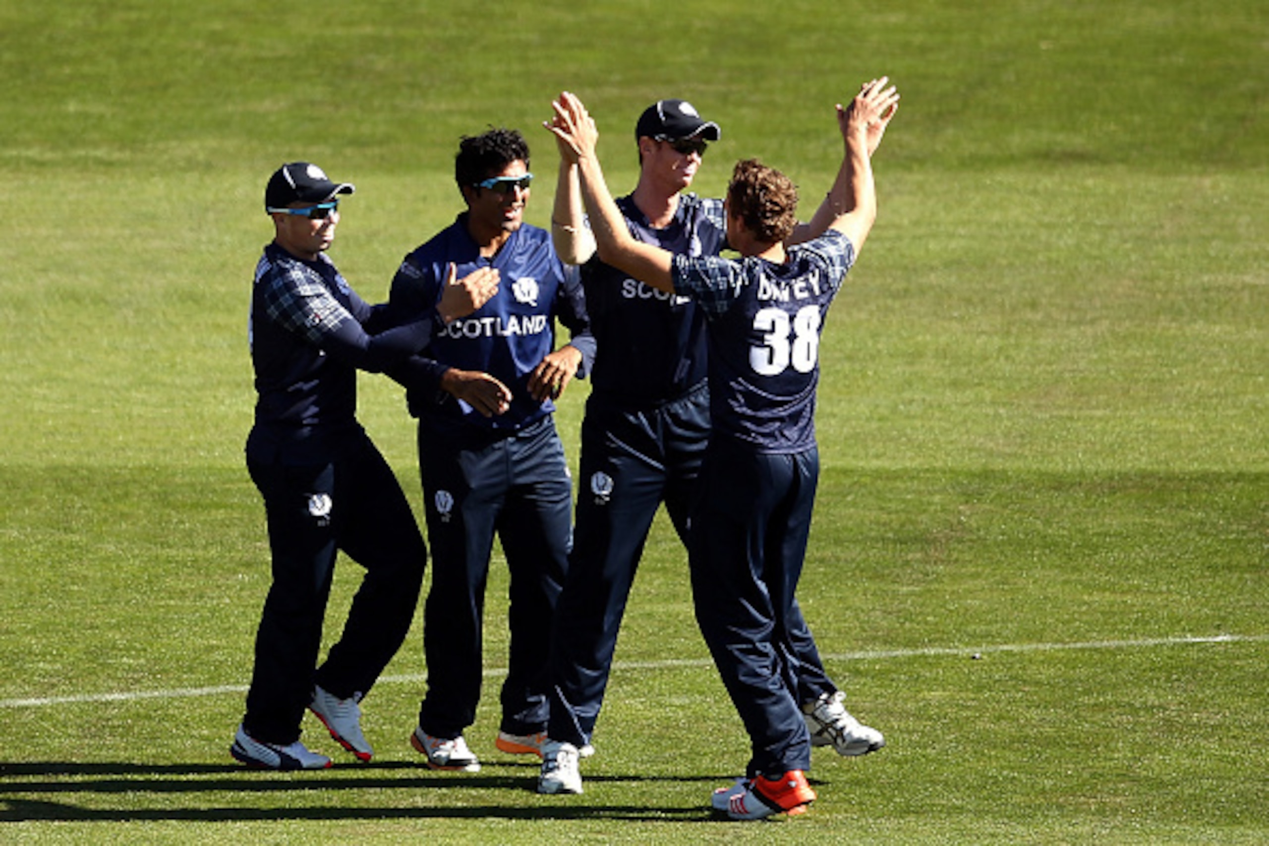 DUNEDIN, NEW ZEALAND - FEBRUARY 26:  Scotland team mates celebrate a wicket during the 2015 ICC Cricket World Cup match between Afghanistan and Scotland at University Oval on February 26, 2015 in Dunedin, New Zealand.  (Photo by Martin Hunter/Getty Images