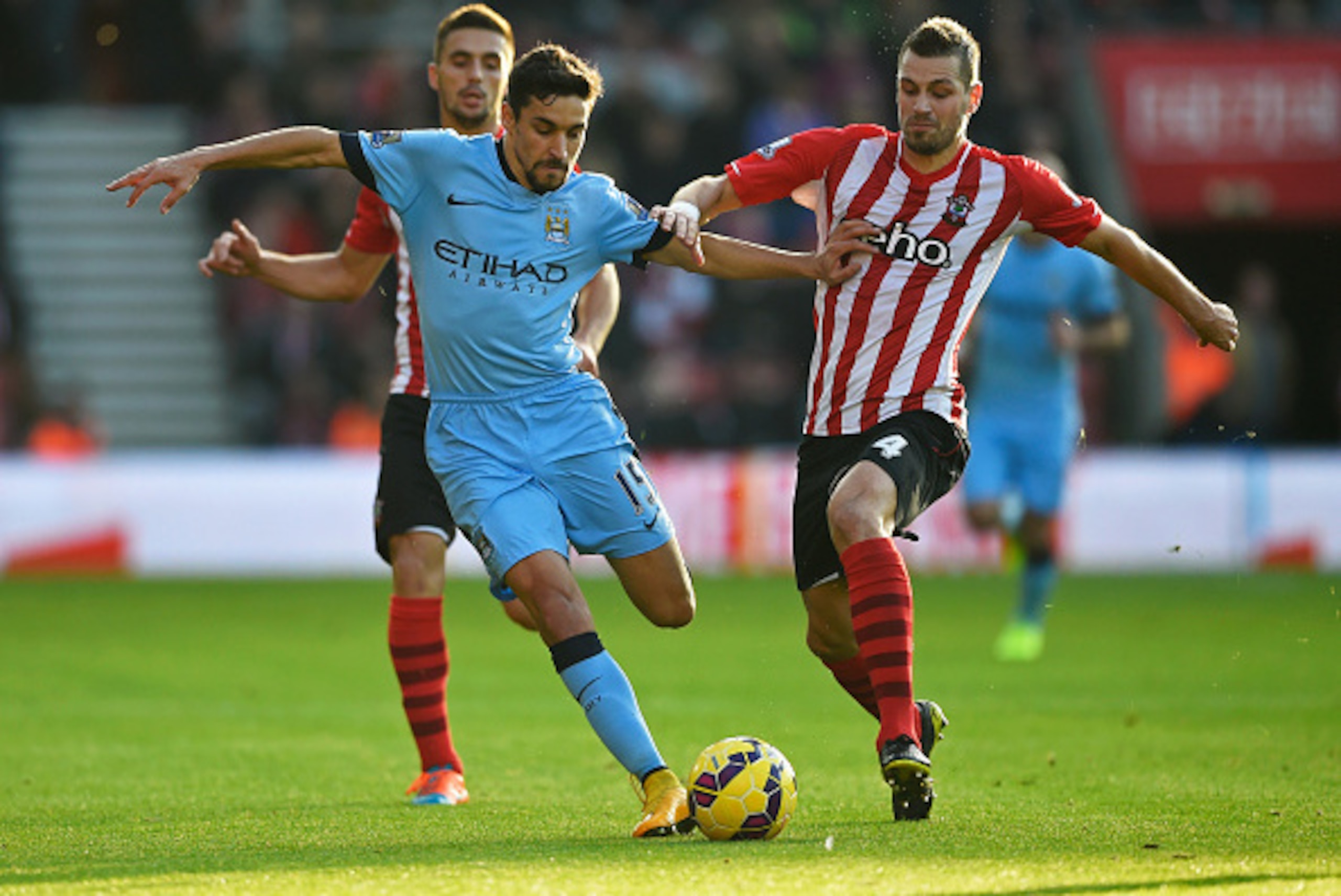 SOUTHAMPTON, ENGLAND - NOVEMBER 30:  Jesus Navas of Manchester City holds off Morgan Schneiderlin of Southampton during the Barclays Premier League match between Southampton and Manchester City at St Mary's Stadium on November 30, 2014 in Southampton, Eng