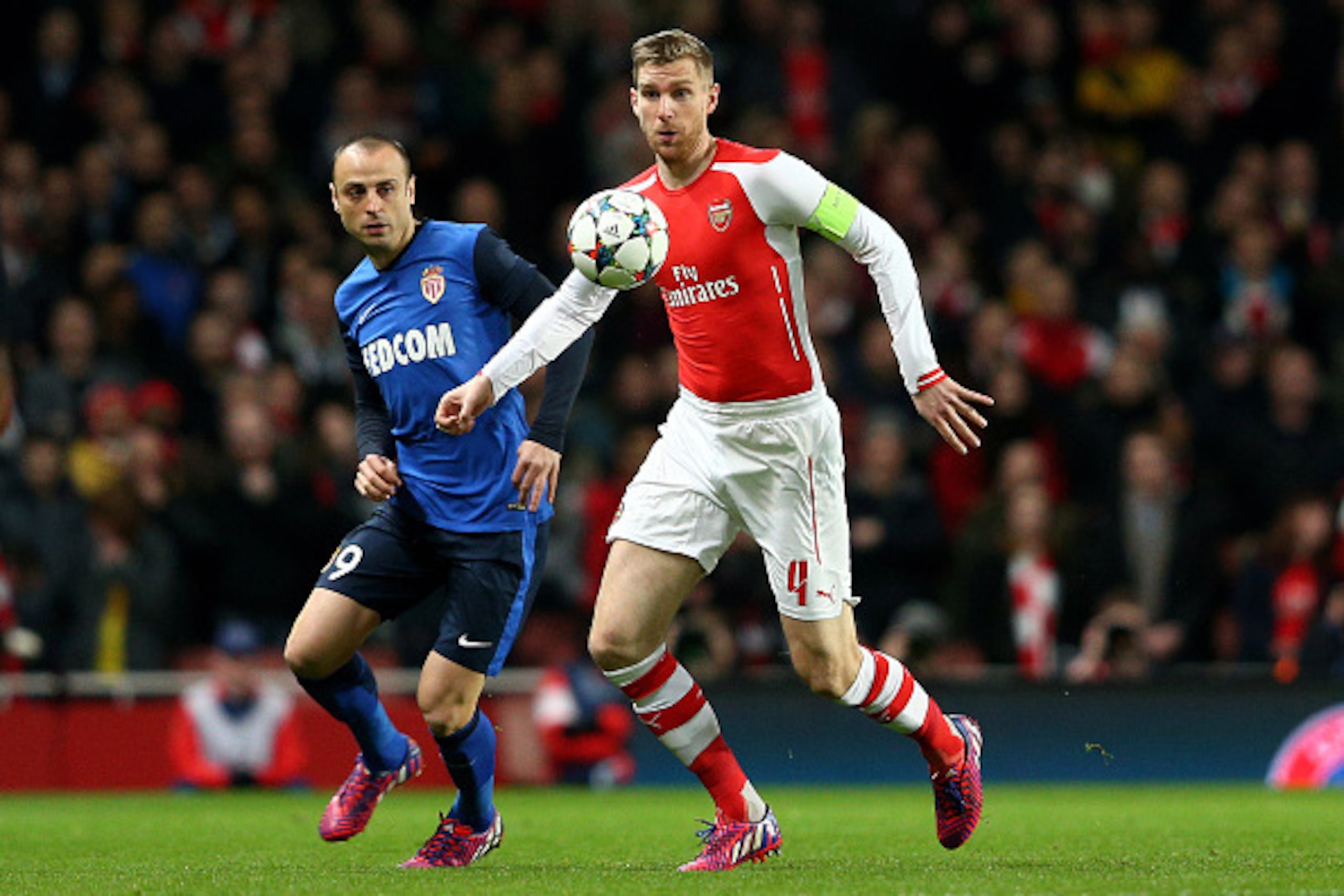 LONDON, ENGLAND - FEBRUARY 25:  Per Mertesacker of Arsenal controls the ball as Dimitar Berbatov of Monaco closes in during the UEFA Champions League round of 16, first leg match between Arsenal and Monaco at The Emirates Stadium on February 25, 2015 in L