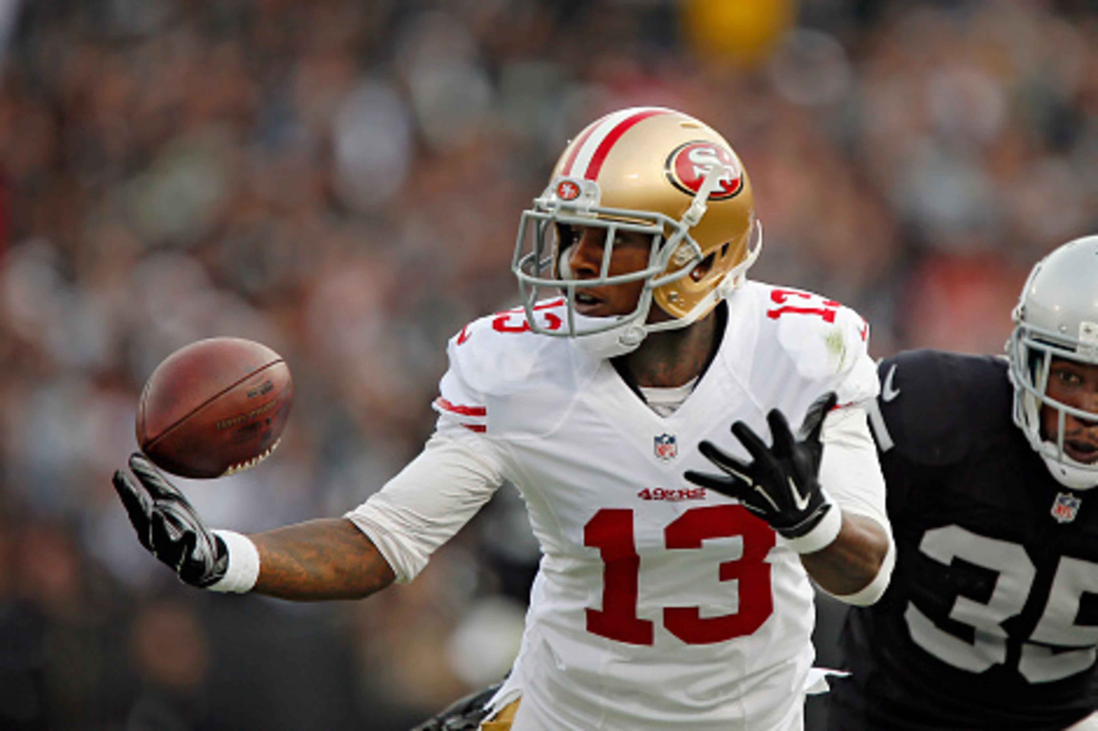 OAKLAND, CA - DECEMBER 7:  Wide receiver Stevie Johnson #13 of the San Francisco 49ers tries unsuccessfully to pull down a pass against cornerback Chimdi Chekwa #35 of the Oakland Raiders in the second quarter on December 7, 2014 at O.co Coliseum in Oakla