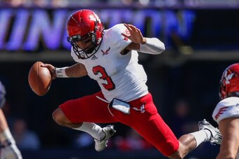 SEATTLE, WA - SEPTEMBER 06:  Quarterback Vernon Adams Jr. #3 of the Eastern Washington Eagles hurdles linebacker Hau'oli Kikaha #8 of the Washington Huskies on September 6, 2014 at Husky Stadium in Seattle, Washington. The Huskies defeated the Eagles 59-5