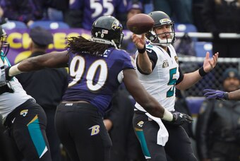Dec 14, 2014; Baltimore, MD, USA; Jacksonville Jaguars quarterback Blake Bortles (5) throws as Baltimore Ravens linebacker Pernell McPhee (90) defends during the second quarter at M&T Bank Stadium. Mandatory Credit: Tommy Gilligan-USA TODAY Sports