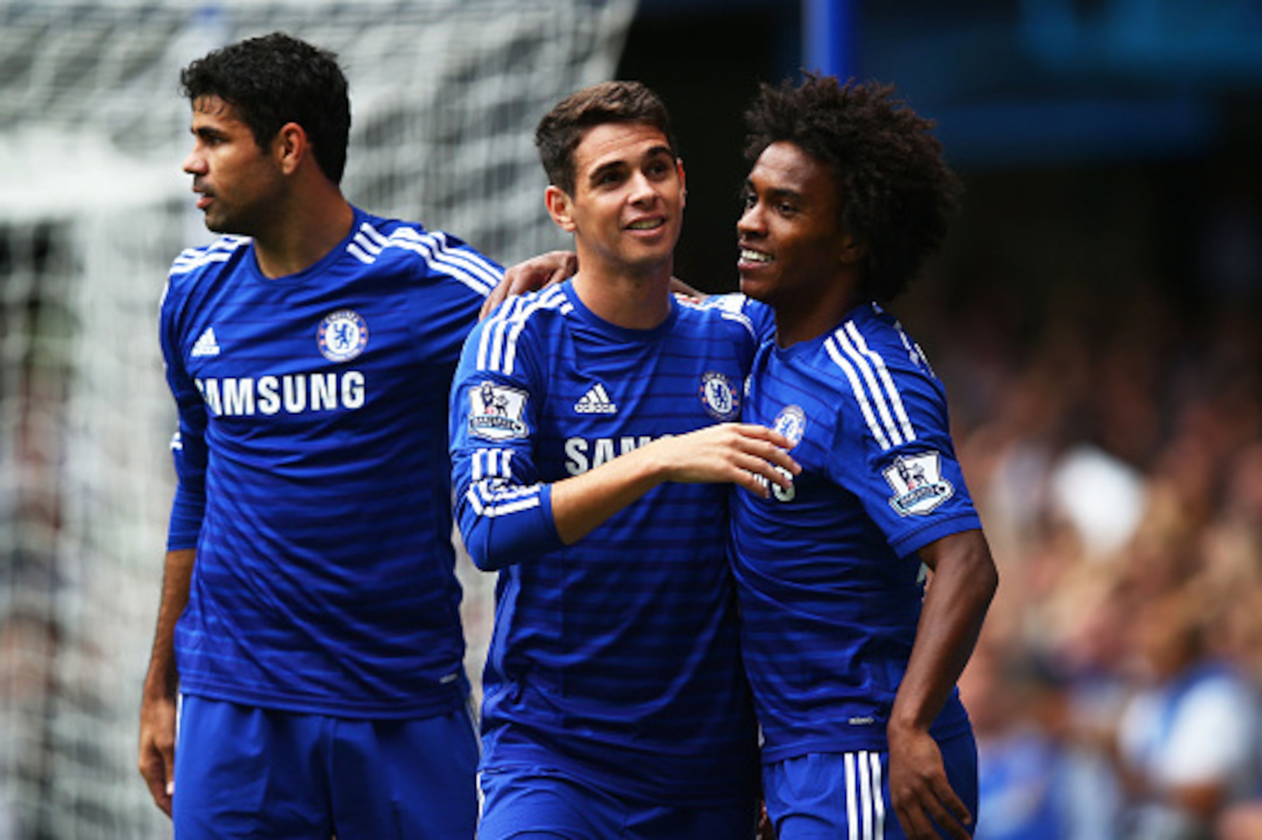 LONDON, ENGLAND - SEPTEMBER 27:  Oscar of Chelsea celebrates with teammates Diego Costa (L) and Willian (R) of Chelsea after scoring the opening goal during the Barclays Premier League match between Chelsea and Aston Villa at Stamford Bridge on September 