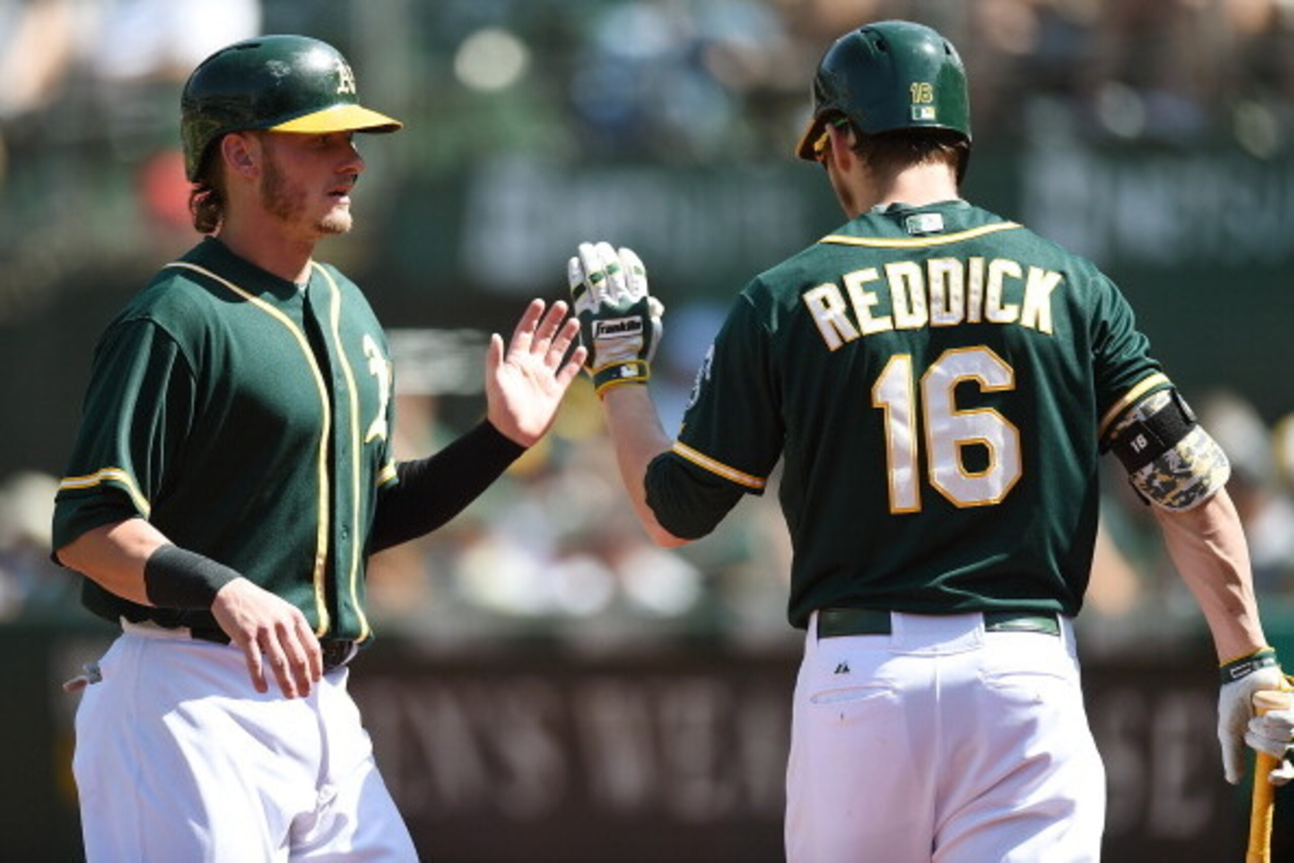 OAKLAND, CA - MAY 29:  Josh Donaldson #20 of the Oakland Athletics is congratulated by Josh Reddick #16 after Donaldson scored in the bottom of the ninth inning against the Detroit Tigers at O.co Coliseum on May 29, 2014 in Oakland, California. The Tigers