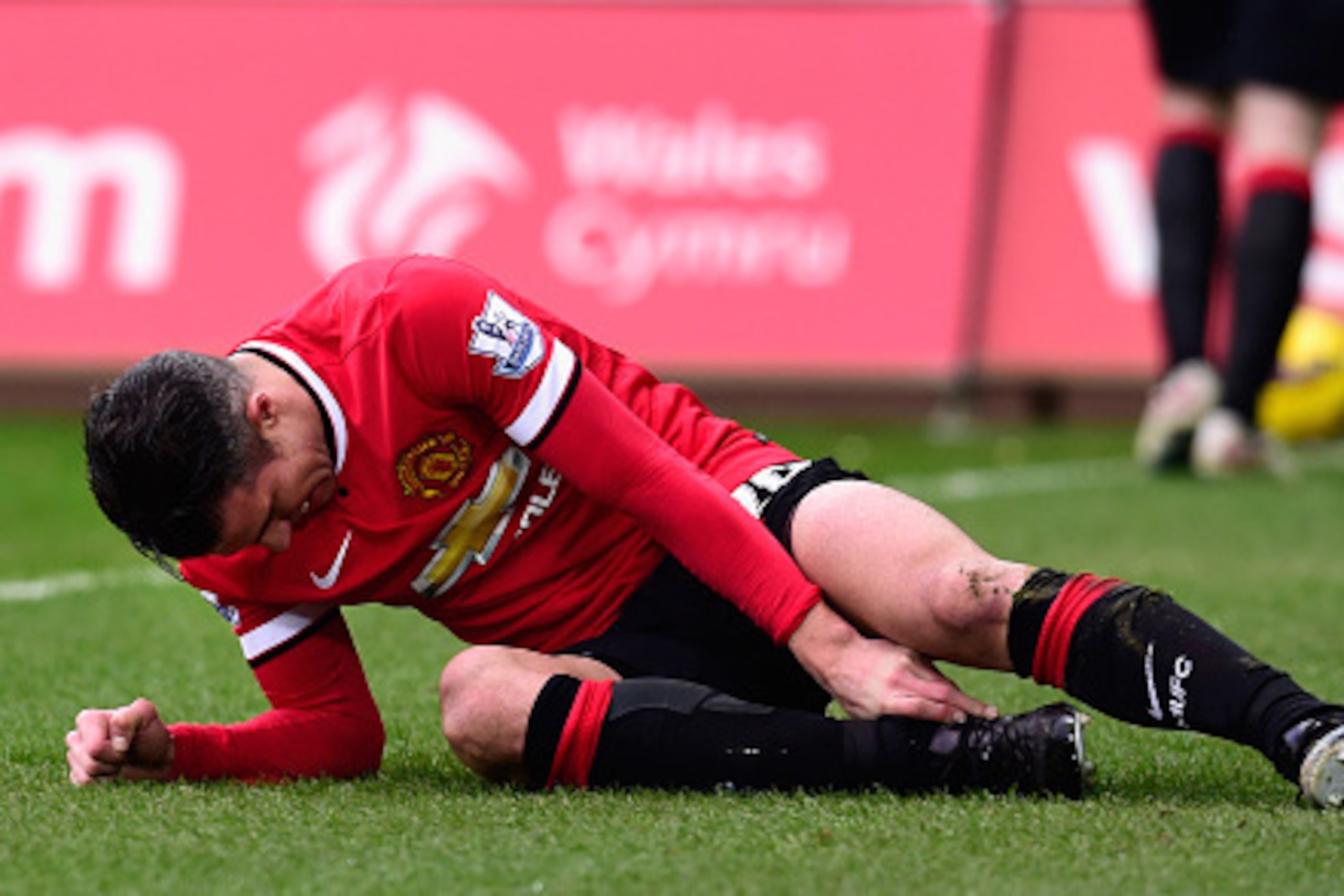 SWANSEA, WALES - FEBRUARY 21:  Robin Van Persie  of Manchester United lies injured during the Barclays Premier League match between Swansea City and Manchester United at Liberty Stadium on February 21, 2015 in Swansea, Wales.  (Photo by Stu Forster/Getty 