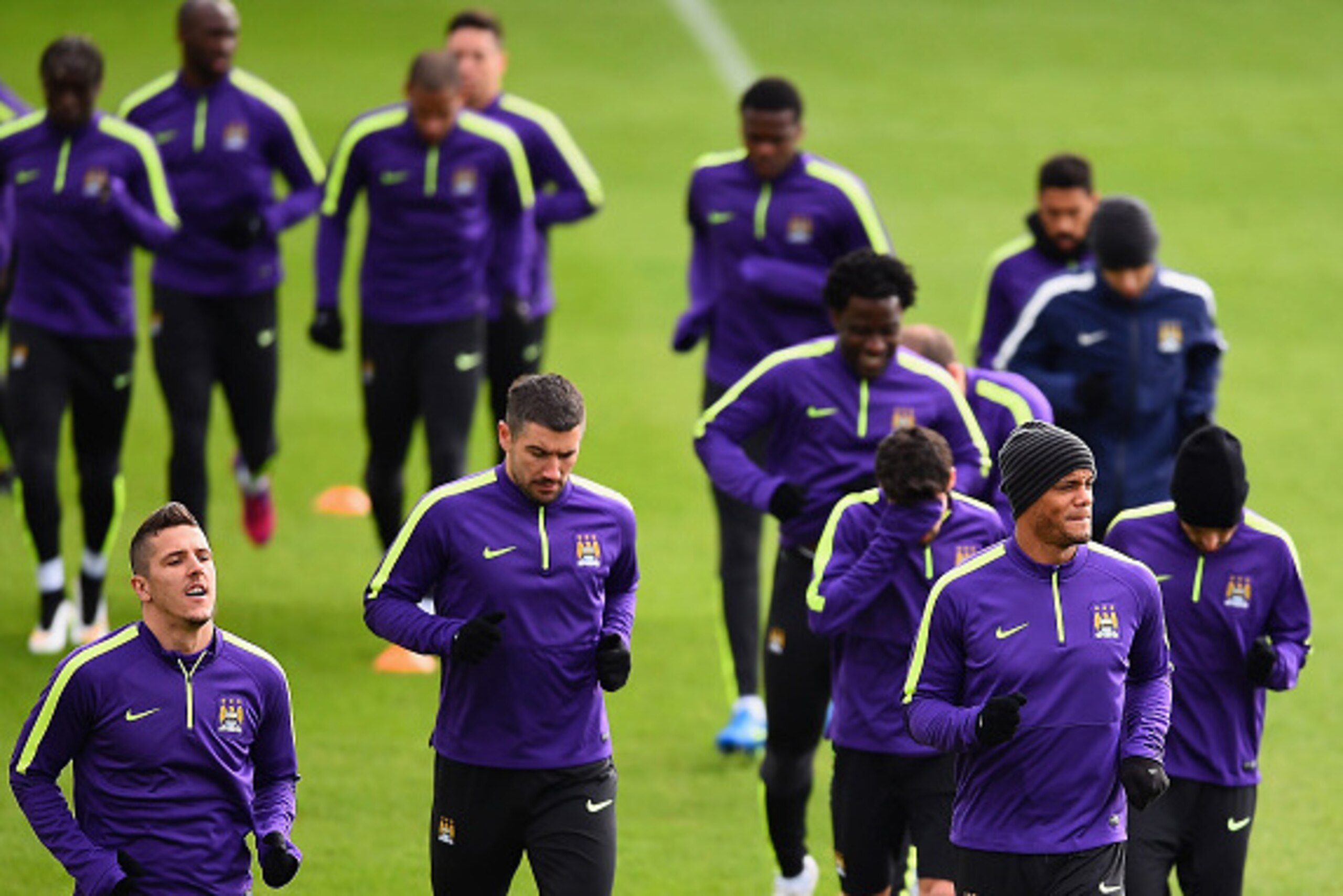 MANCHESTER, ENGLAND - FEBRUARY 23: Stevan Jovetic, Aleksandar Kolarov and Vincent Kompany of Manchester City jog during a Manchester City training session ahead of the UEFA Champions League round of 16 first leg match against Barcelona at Etihad Campus on