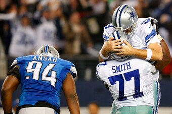 ARLINGTON, TX - JANUARY 04:  Tony Romo #9 of the Dallas Cowboys and Tyron Smith #77 of the Dallas Cowboys celebrate a Cowboy touchdown as Ezekiel Ansah #94 of the Detroit Lions is near during the second half of their NFC Wild Card Playoff game at AT&T Sta