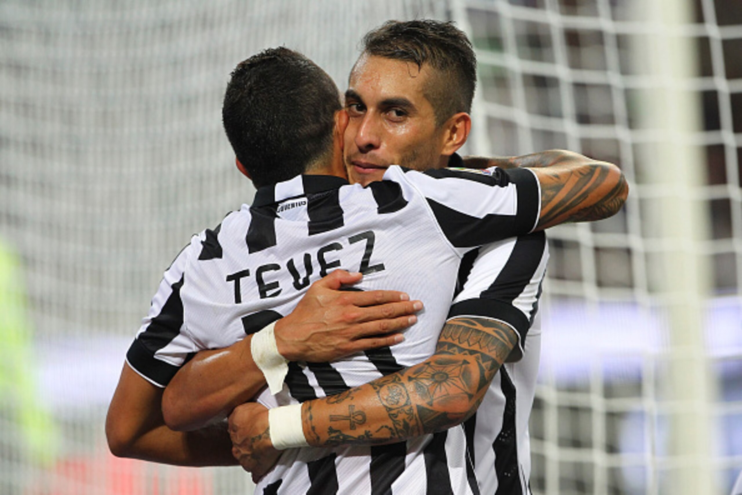 MILAN, ITALY - SEPTEMBER 20:  Carlos Tevez of Juventus FC celebrates with his team-mate Roberto Maximiliano Pereyra after scoring the opening goal during the Serie A match between AC Milan and Juventus FC at Stadio Giuseppe Meazza on September 20, 2014 in
