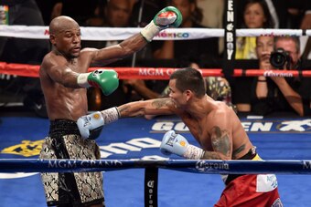 LAS VEGAS, NV - SEPTEMBER 13:  Floyd Mayweather Jr. (L) avoids a right by Marcos Maidana in the 10th round of their WBC/WBA welterweight title fight at the MGM Grand Garden Arena on September 13, 2014 in Las Vegas, Nevada. Mayweather Jr. won by unanimous 