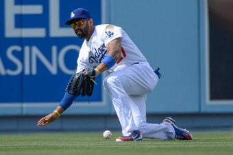 Apr 27, 2014; Los Angeles, CA, USA; Los Angeles Dodgers center fielder Matt Kemp (27) drops a fly ball of the bat of Colorado Rockies second baseman Josh Rutledge (14) in the eighth inning at Dodger Stadium. Kemp was charged with an error on the play. Man