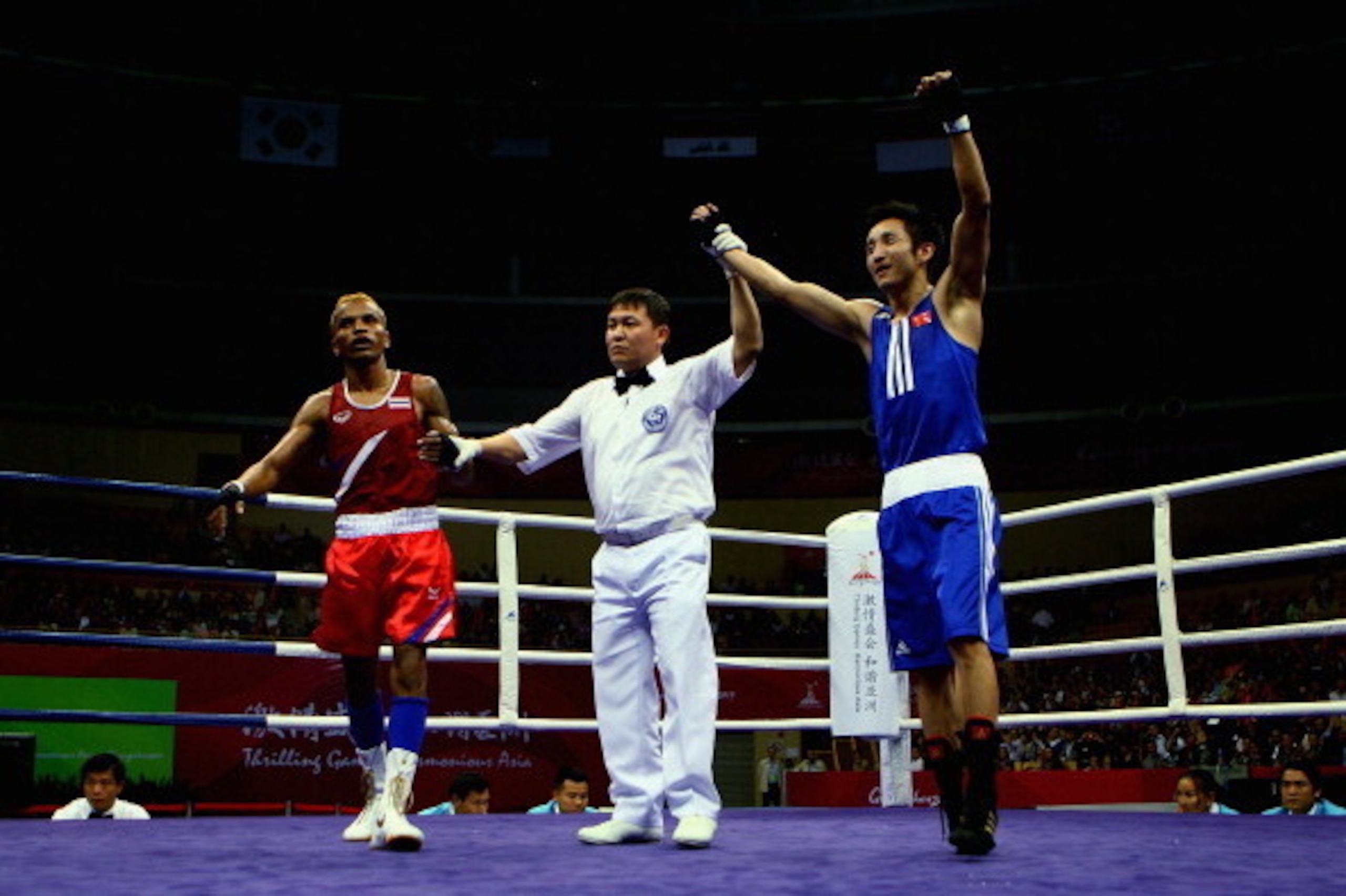 GUANGZHOU, CHINA - NOVEMBER 24:  Olympic Gold Medalist Zou Shiming of China competes against Amnat Ruenroeng of Thailand in the Men's 46-49kg Semifinal at Foshan Gynasium during day twelve of the 16th Asian Games Guangzhou 2010 on November 24, 2010 in Gua
