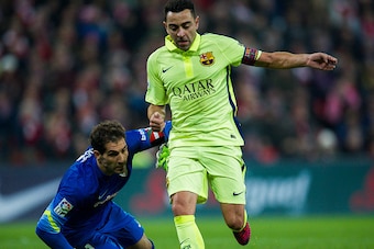 BILBAO, SPAIN - FEBRUARY 08:  Xavi Hernandez of FC Barcelona duels for the ball with Gorka Iraizoz of Athletic Club during the La Liga match between Athletic Club and FC Barcelona at San Mames Stadium on February 8, 2015 in Bilbao, Spain.  (Photo by Juan 