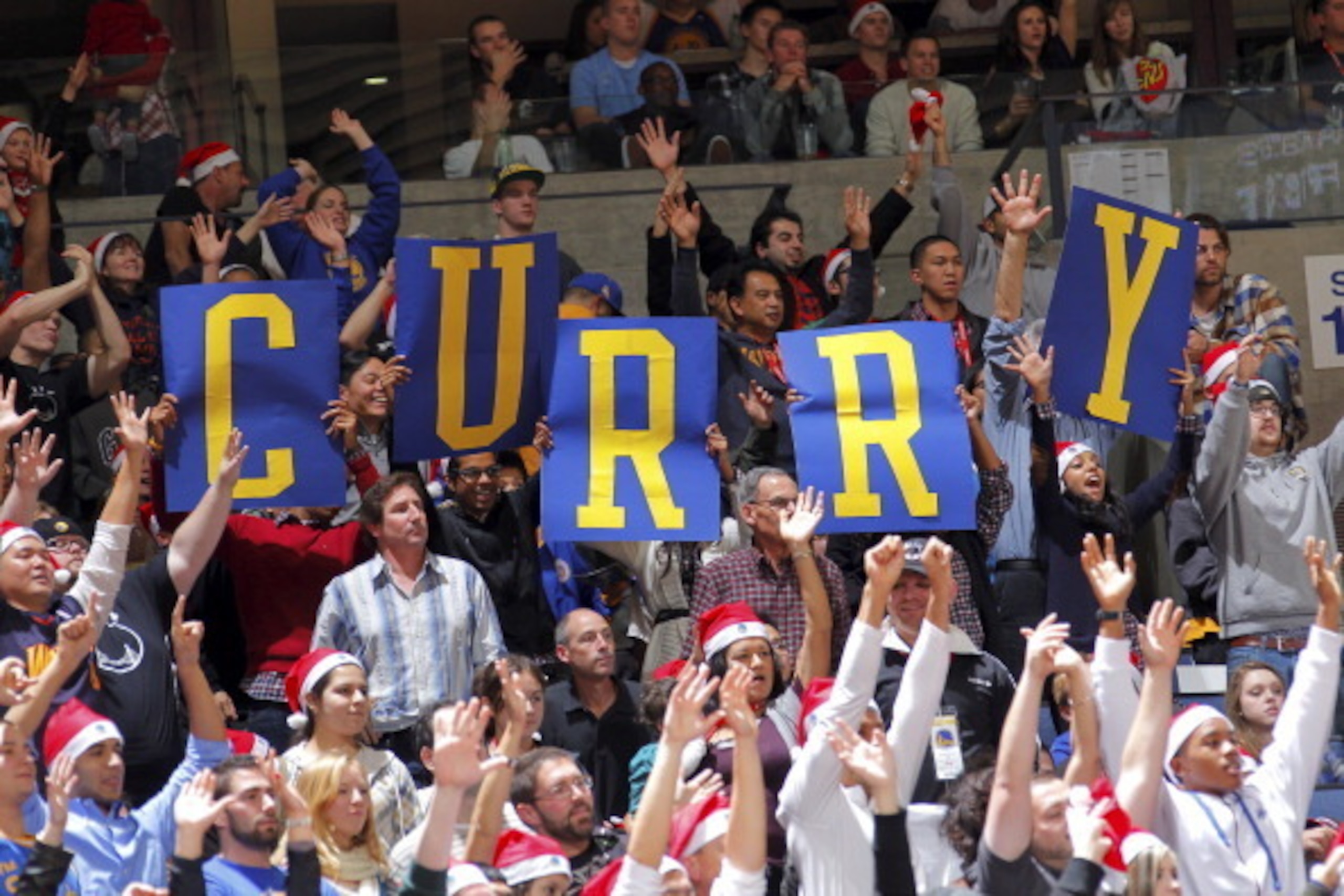 OAKLAND, CA - DECEMBER 25: Golden State Warriors fans cheer for Stephen Curry #30 against the Portland Trail Blazers on December 25, 2010 at Oracle Arena in Oakland, California. NOTE TO USER: User expressly acknowledges and agrees that, by downloading and