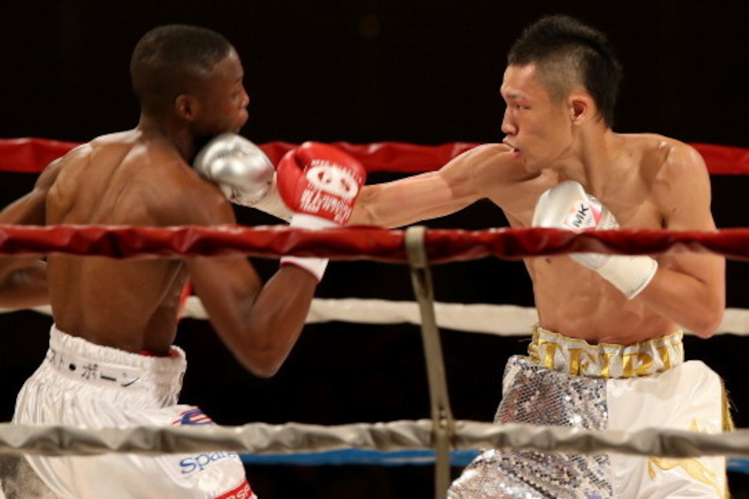 KOBE, JAPAN - JULY 18:  Teiru Kinoshita of Japan (R) exchanges punches with Zolani Tete of South Africa during the IBF super flyweight title bout between Teiru Kinoshita and Zolani Tete at Kobe Portopia Hotel on July 18, 2014 in Kobe, Japan.  (Photo by Bu