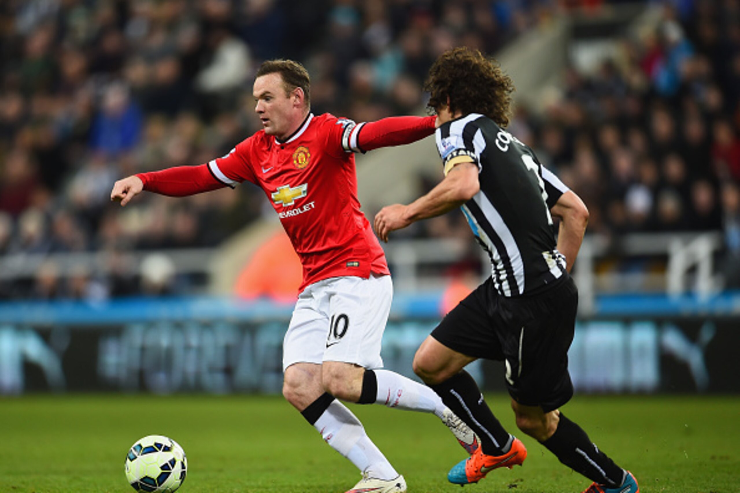 NEWCASTLE UPON TYNE, ENGLAND - MARCH 04:  Fabricio Coloccini of Newcastle United closes down Wayne Rooney of Manchester United during the Barclays Premier League match between Newcastle United and Manchester United at St James' Park on March 4, 2015 in Ne