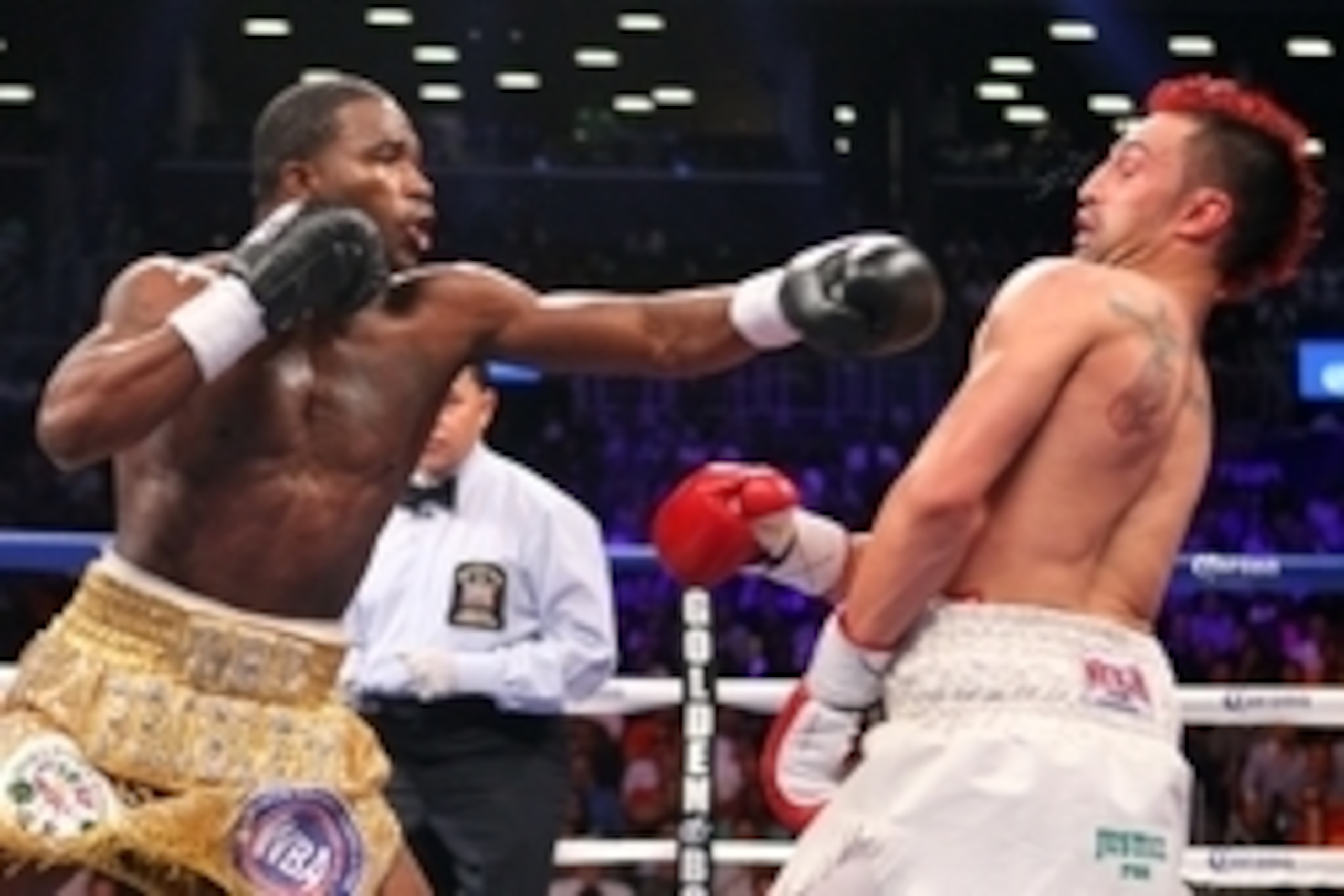 Jun 22, 2013; Brooklyn, NY, USA; Adrien Broner (Gold trunks) and Paulie Malignaggi (White trunks) trade punches during their 12 round WBA welterweight championship bout at the Barclay's Center. Mandatory Credit: Ed Mulholland-USA TODAY Sports