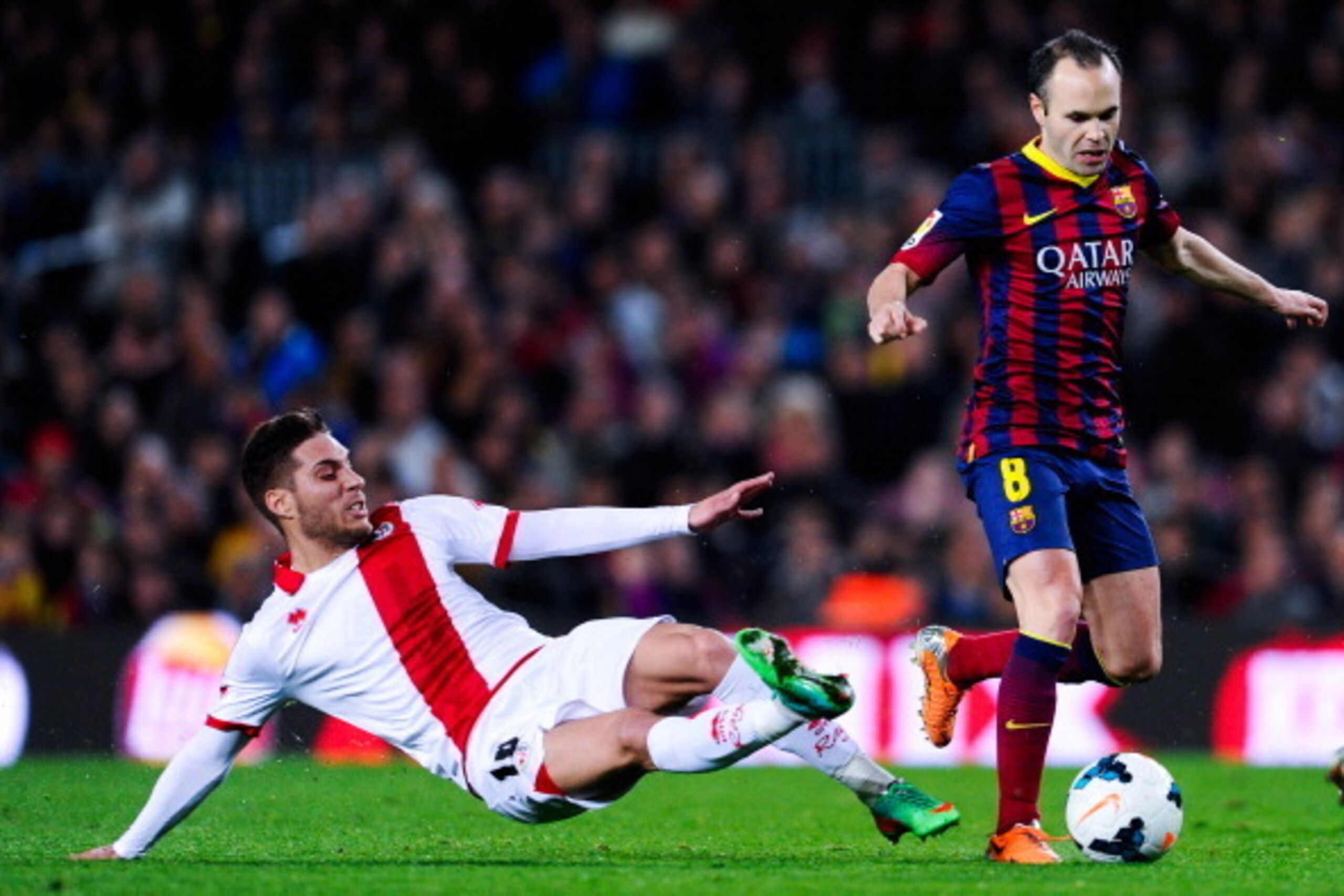 BARCELONA, SPAIN - FEBRUARY 15:  Andres Iniesta of FC Barcelona duels for the ball with Roberto Trashorras of Rayo Vallecano during the La Liga match between FC Barcelona and Rayo Vallecano de Madrid at Camp Nou on February 15, 2014 in Barcelona, Spain.  